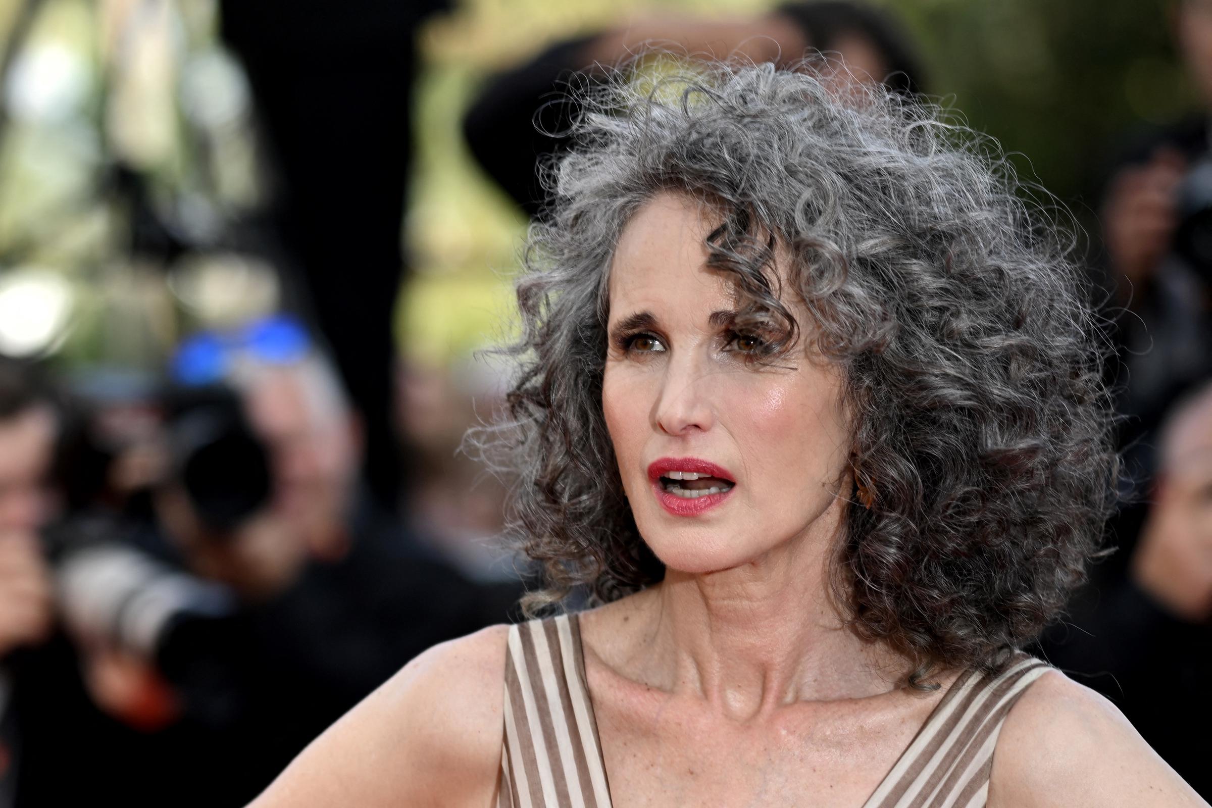 Andie MacDowell luce con orgullo sus rizos grises naturales en el Festival de Cine de Cannes de 2022, en Francia. Su pelo canoso se convirtió en parte de su look característico después de que decidiera dejar de teñírselo durante el confinamiento por la COVID-19. | Fuente: Getty Images