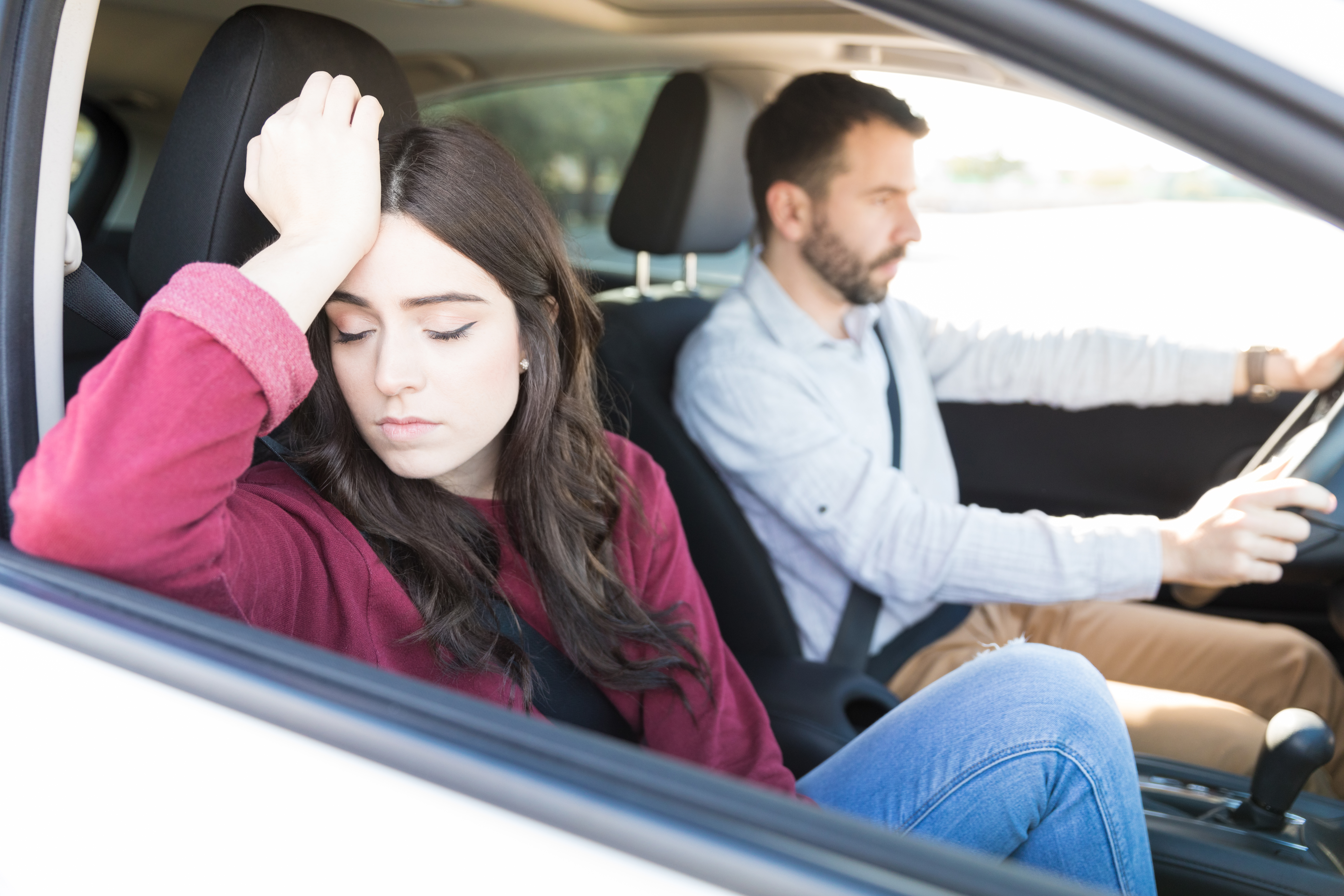 Joven atractiva y triste sentada en el Automóvil con su novio durante un viaje | Fuente: Shutterstock.com
