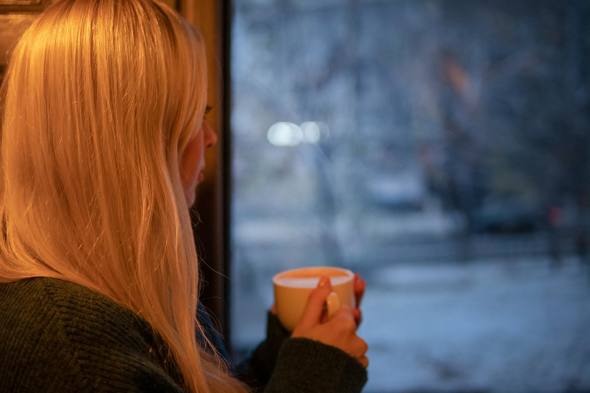 Una mujer mirando por la ventana | Fuente: Pexels