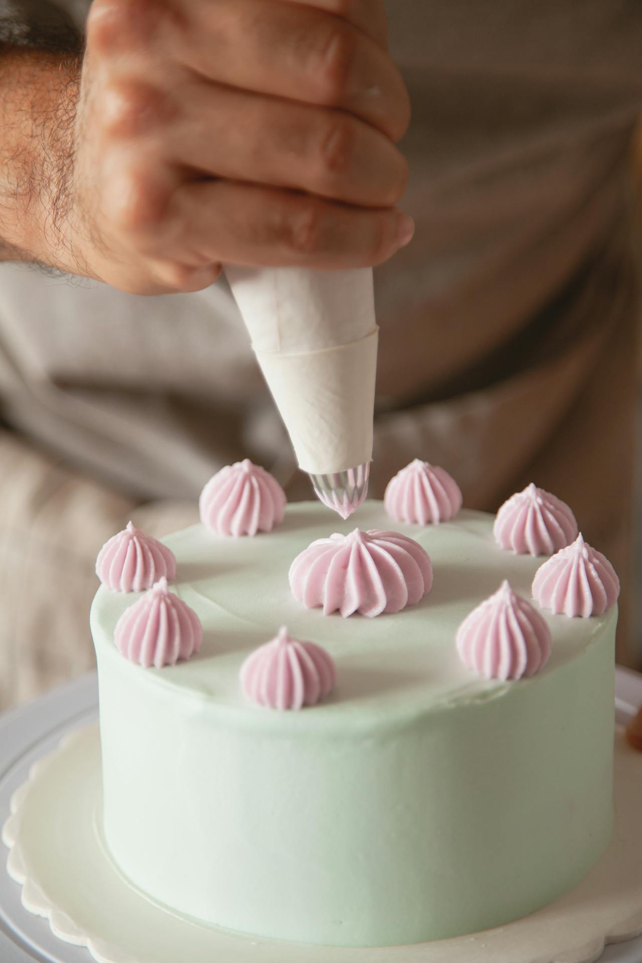 Un hombre decorando un pastel | Fuente: Pexels