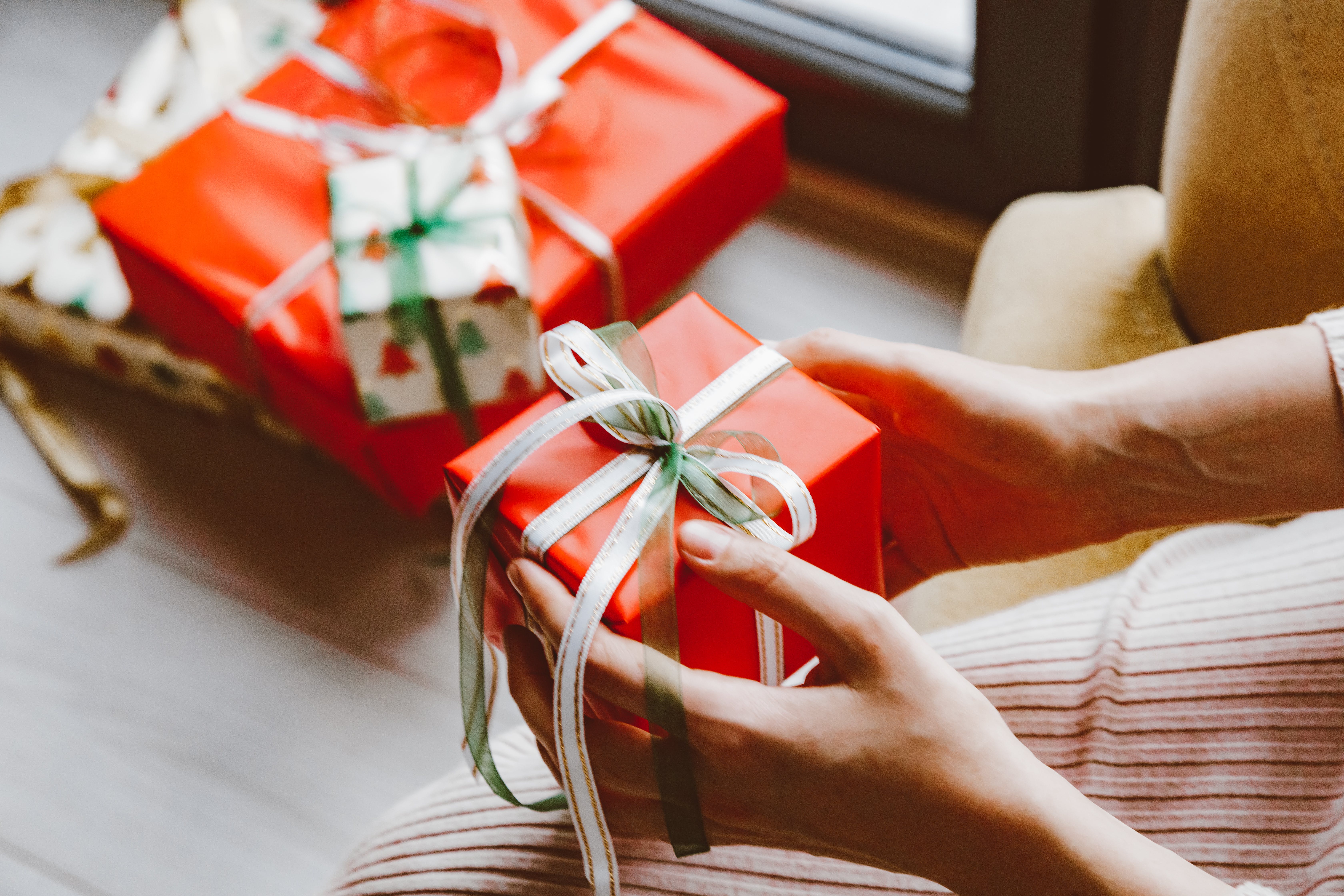 Una persona sosteniendo regalos de Navidad. | Fuente: Pexels