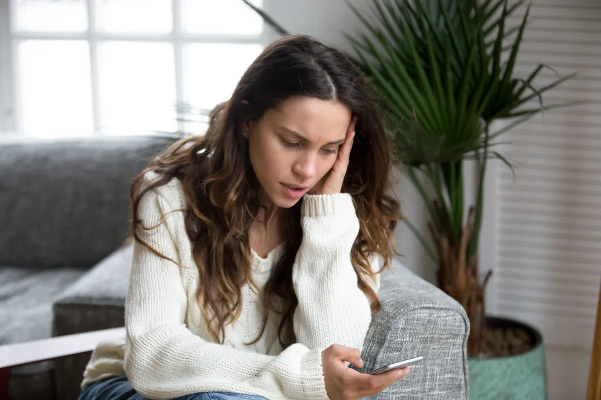 Una mujer molesta mientras lee mensajes en un smartphone | Foto: Shutterstock