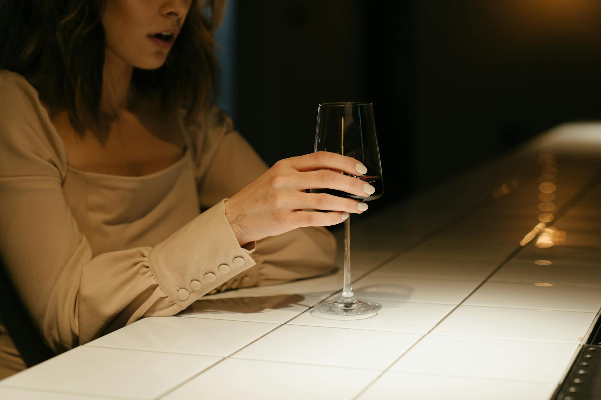 Una mujer con una copa de vino en la mano | Fuente: Pexels