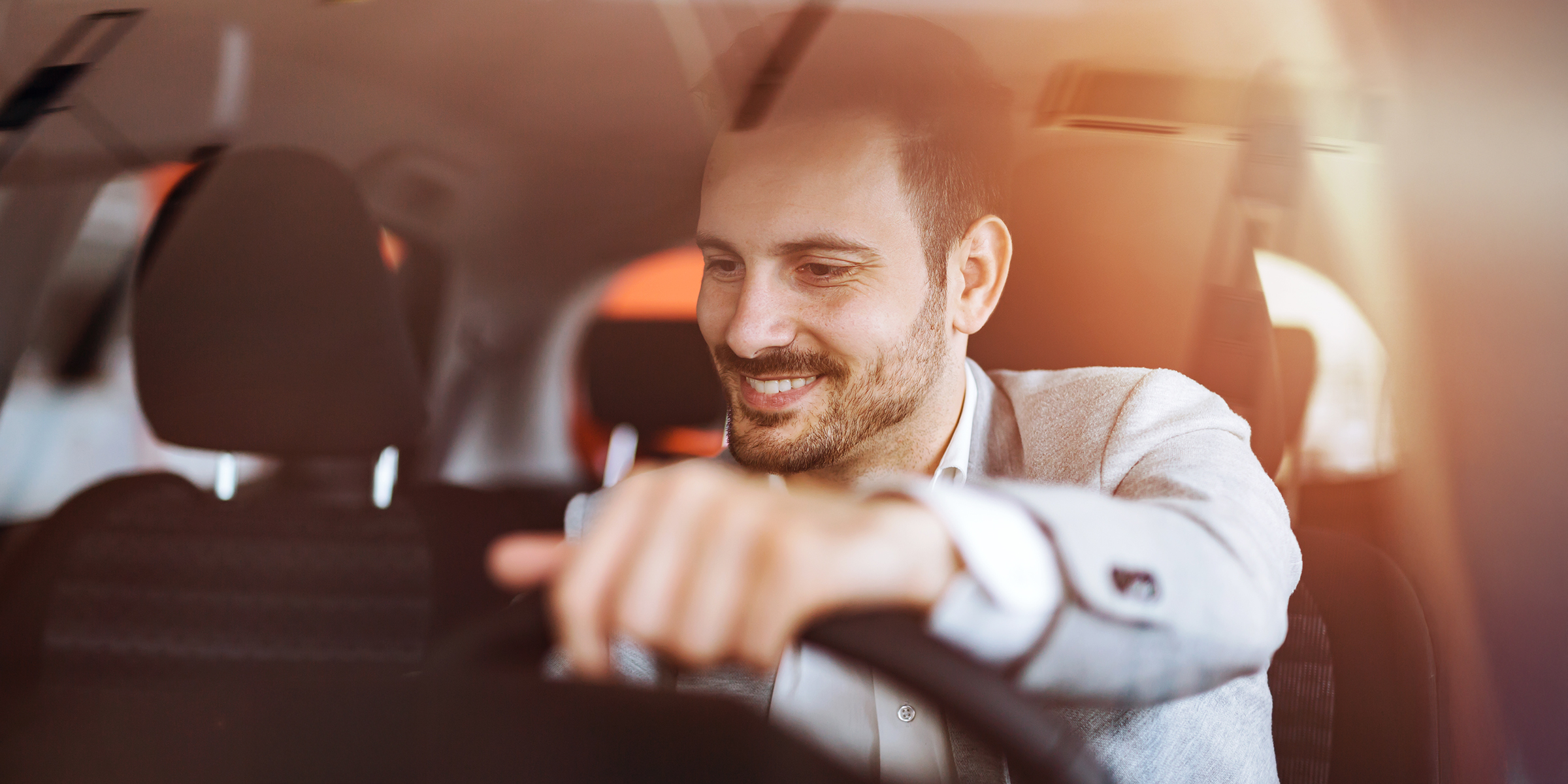 Un hombre sonriente sentado al volante, disfrutando de la conducción de su automóvil | Fuente: Shutterstock