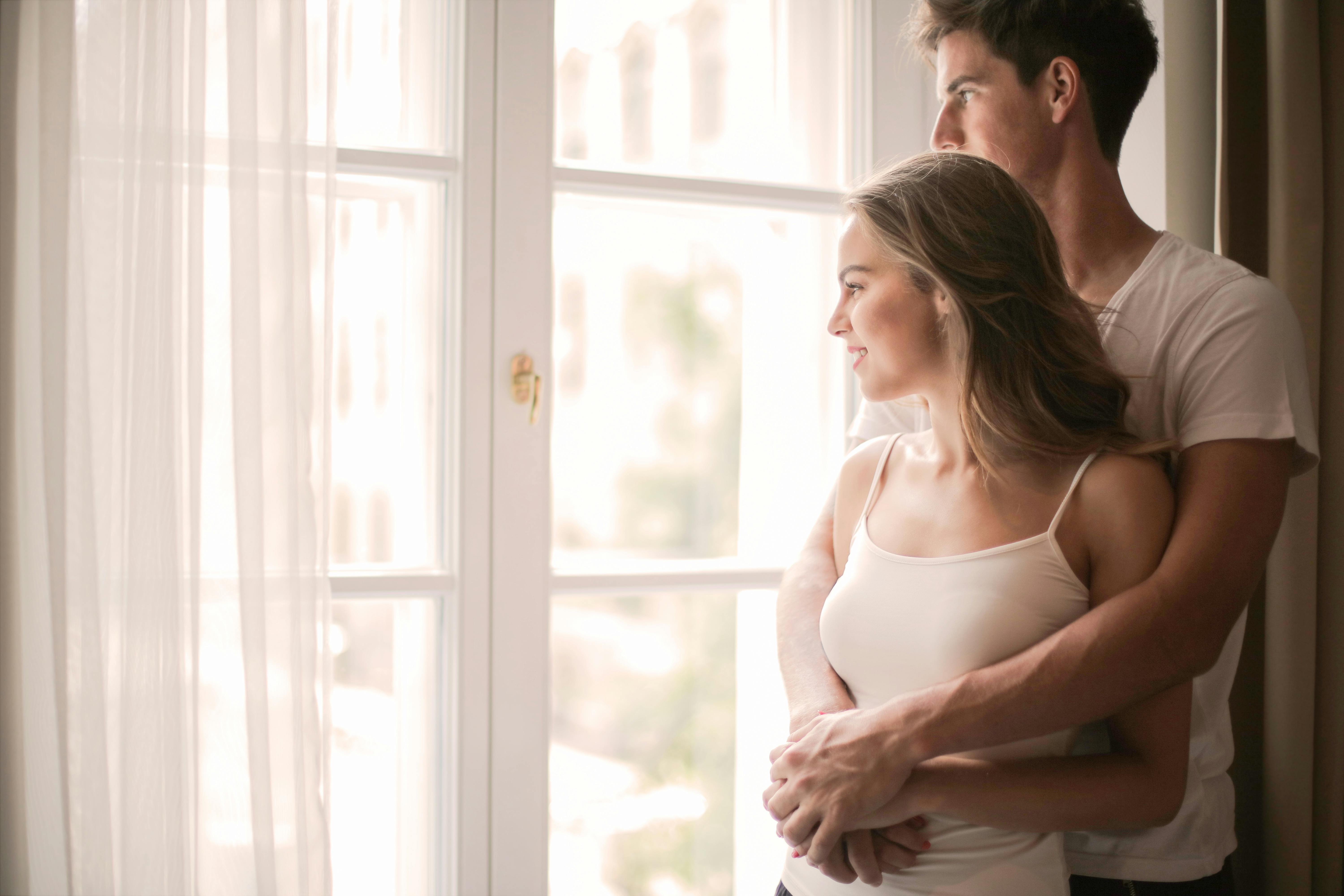 Pareja delante de la ventana | Fuente: Pexels