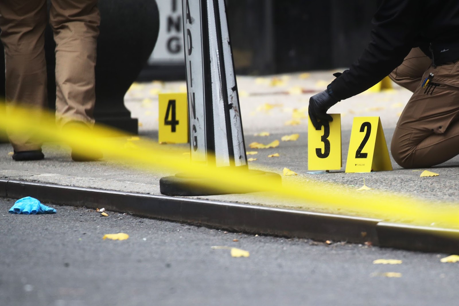 La policía coloca marcadores de casquillos de bala en el exterior del hotel New York Hilton Midtown | Fuente: Getty Images