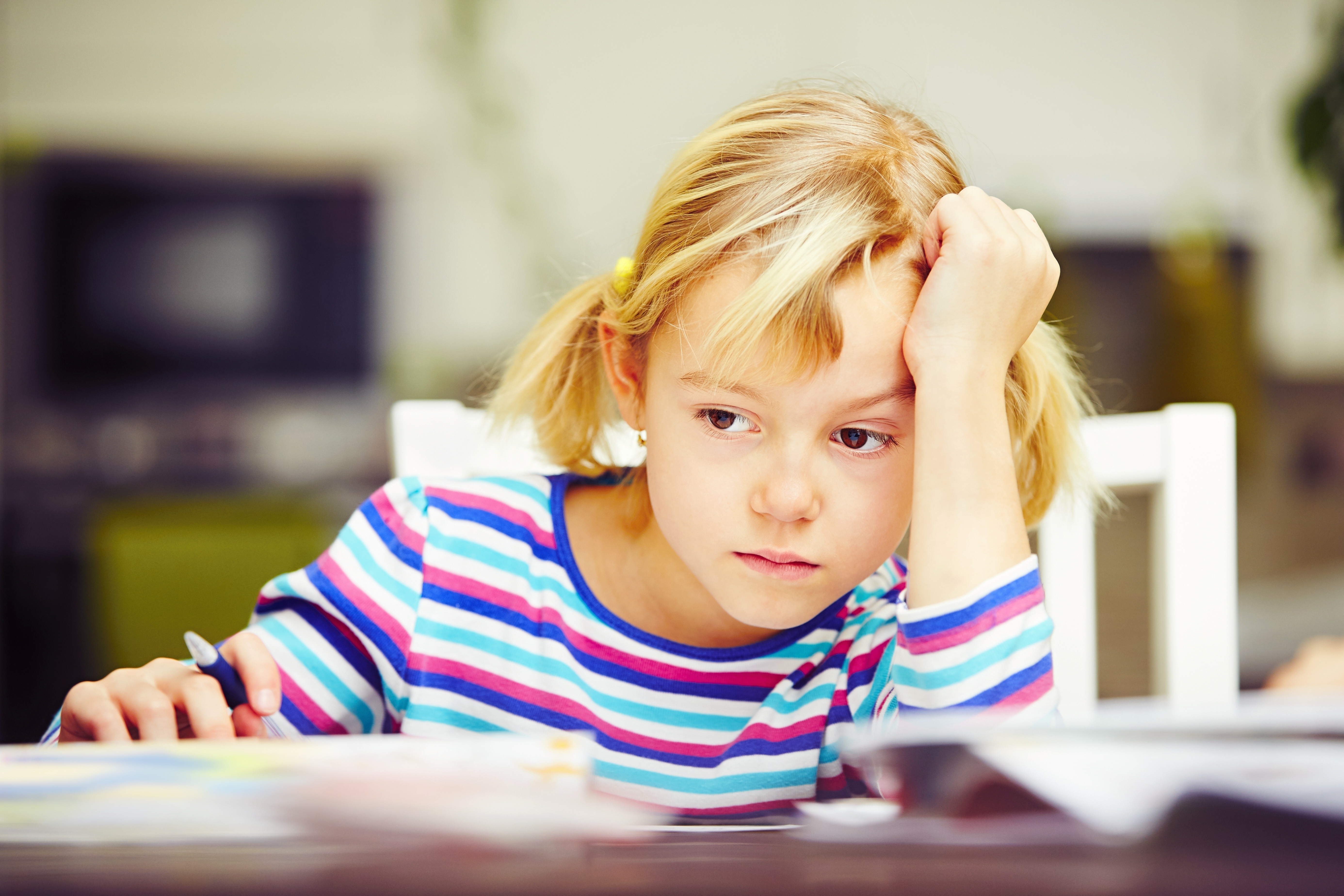 Niña enfurruñada en su escritorio | Foto: Shutterstock