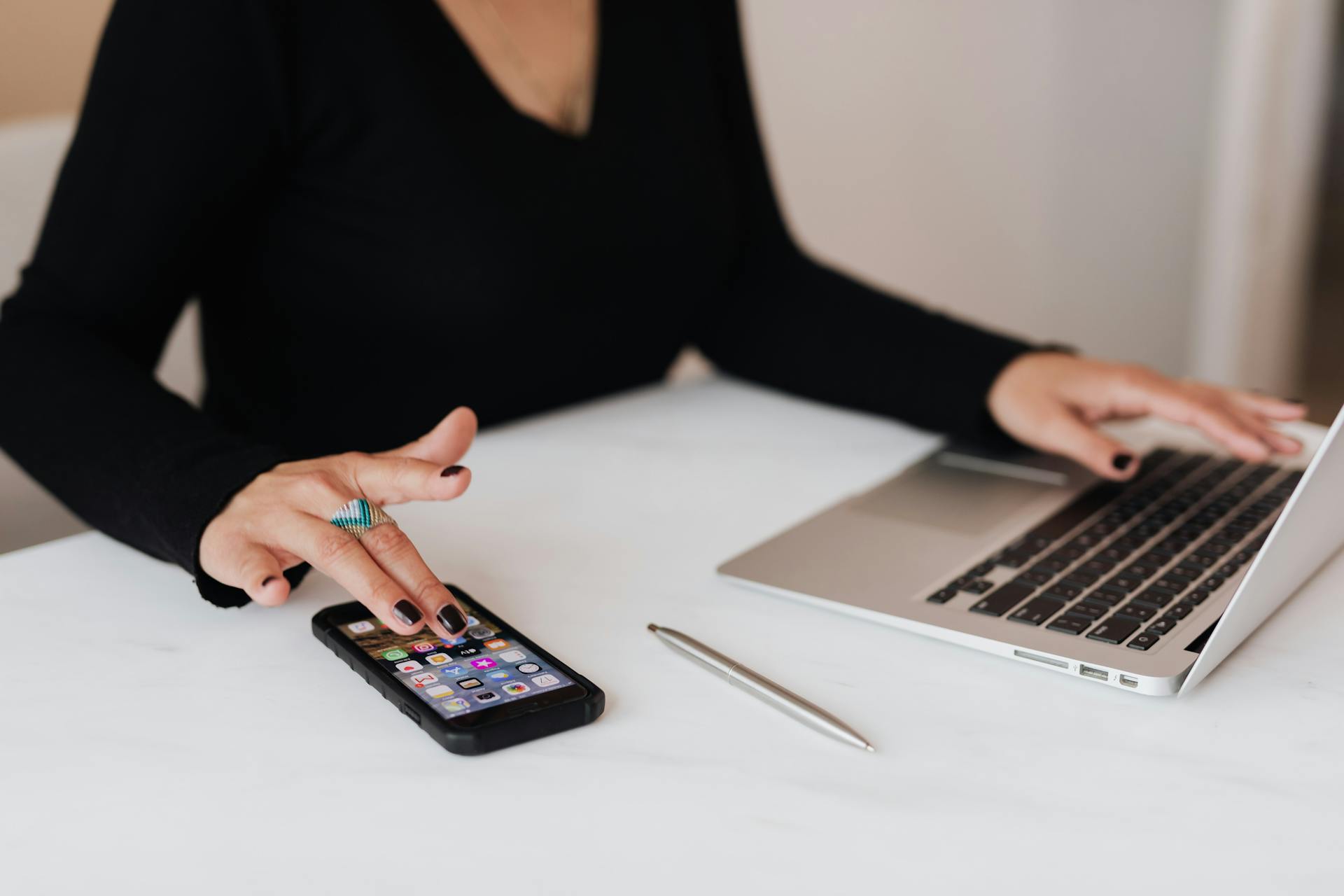 Una mujer utilizando su portátil y su teléfono simultáneamente | Fuente: Pexels