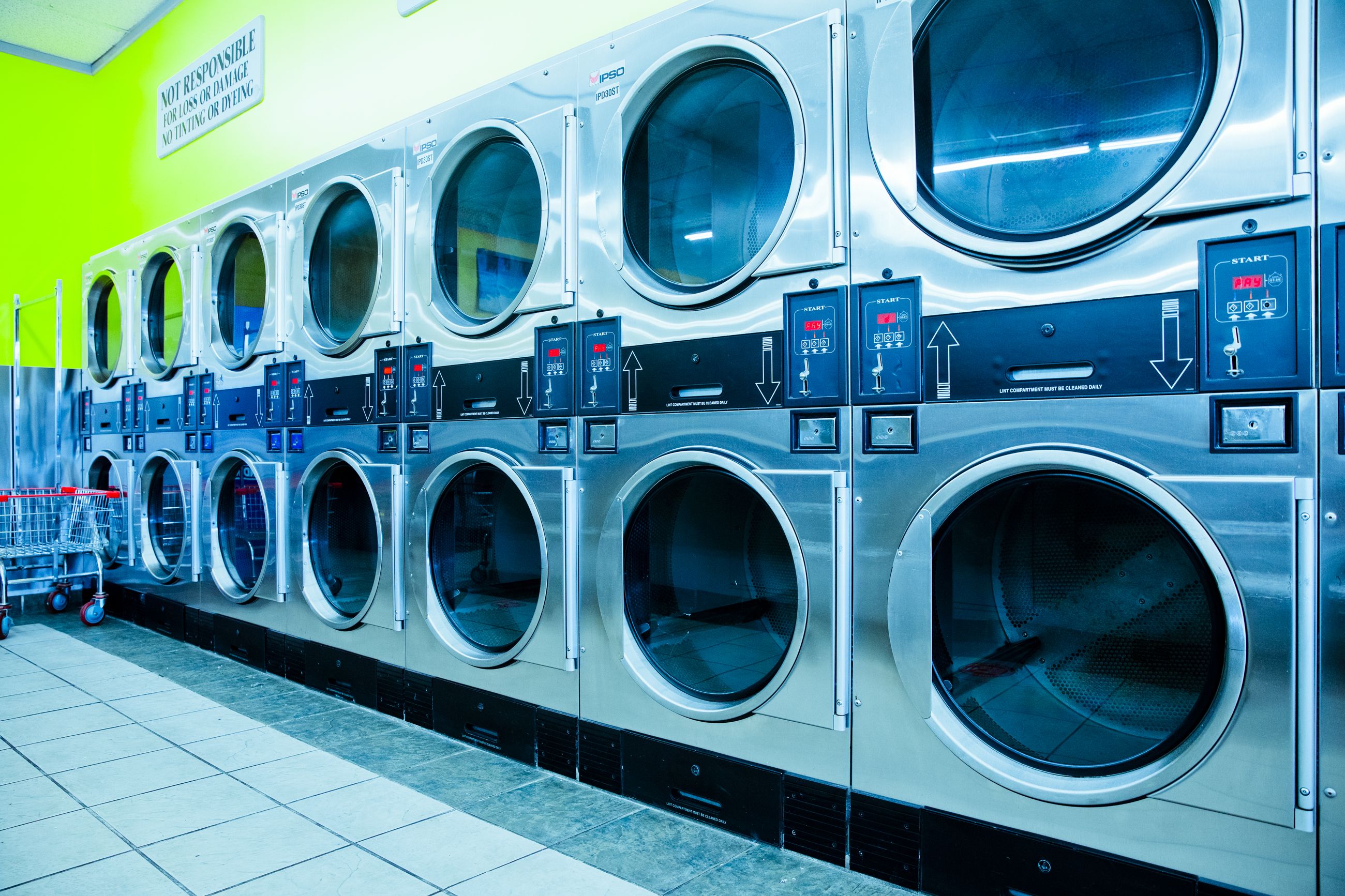 Una lavandería muy luminosa con filas de lavadoras industriales | Fuente: Pexels
