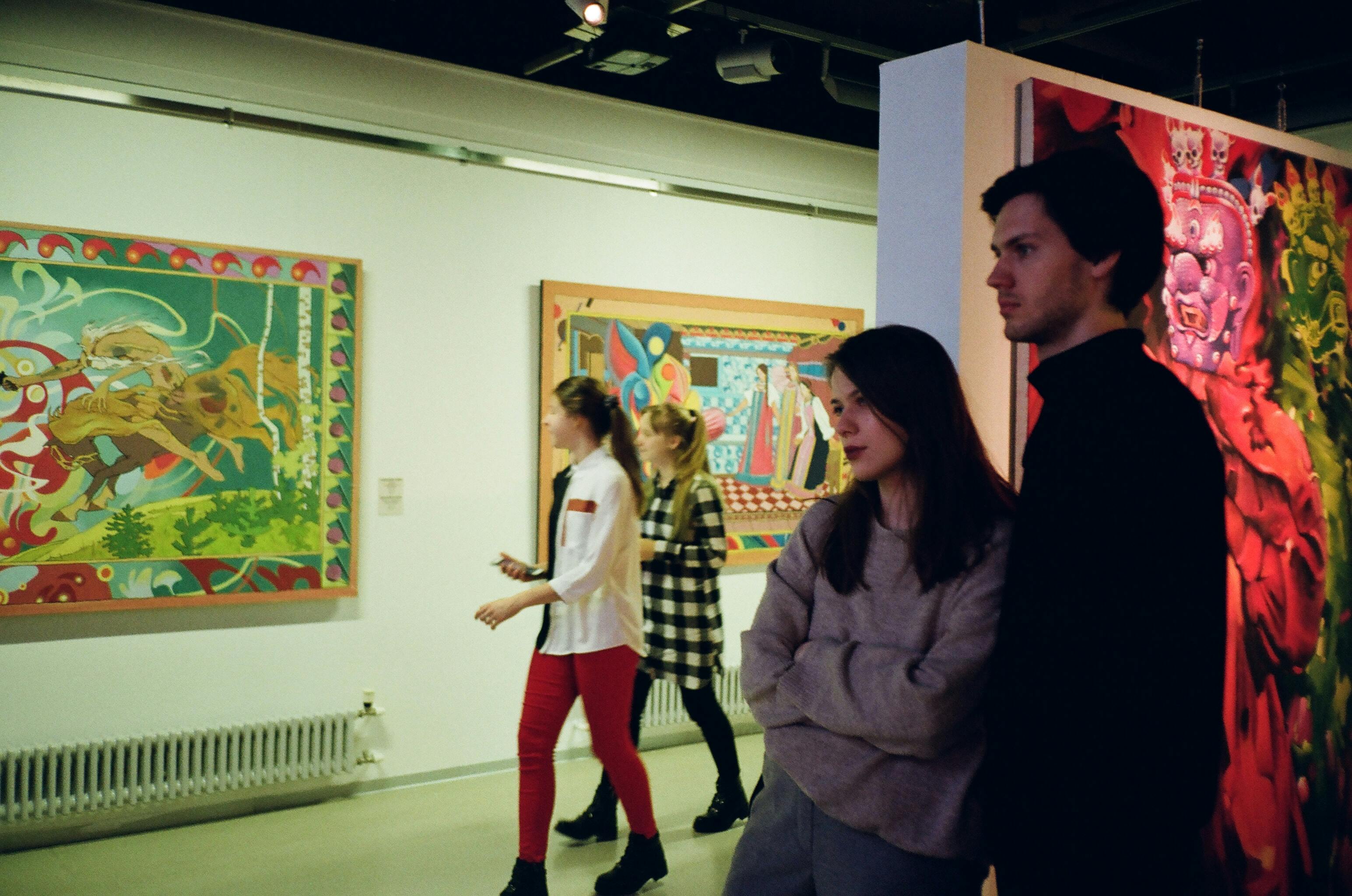 Patrons walk through an art exhibition | Fuente: Pexels