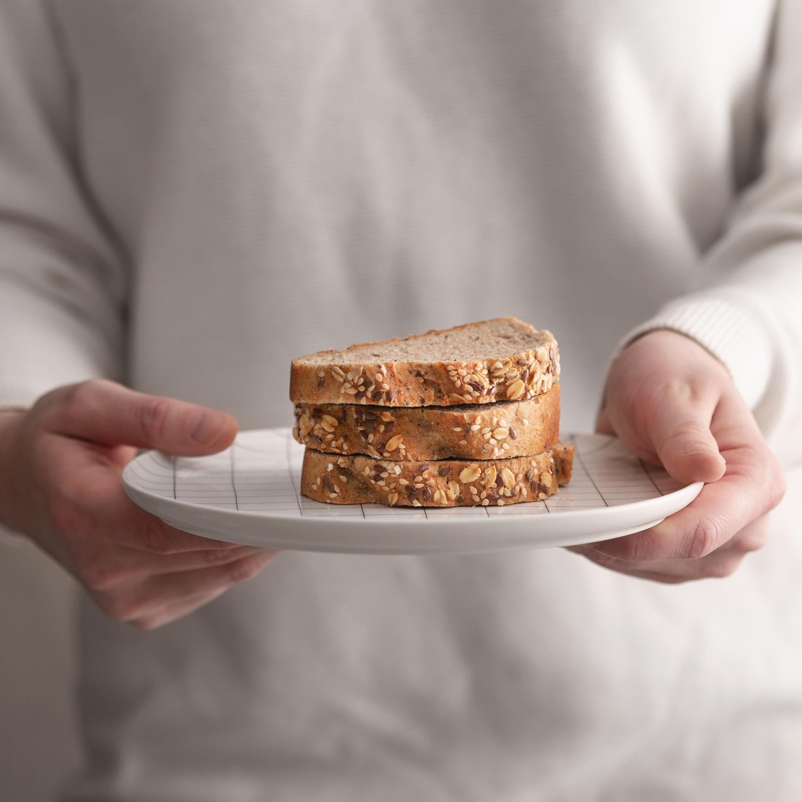 Hombre sujetando un plato de pan de plátano | Fuente: Freepik