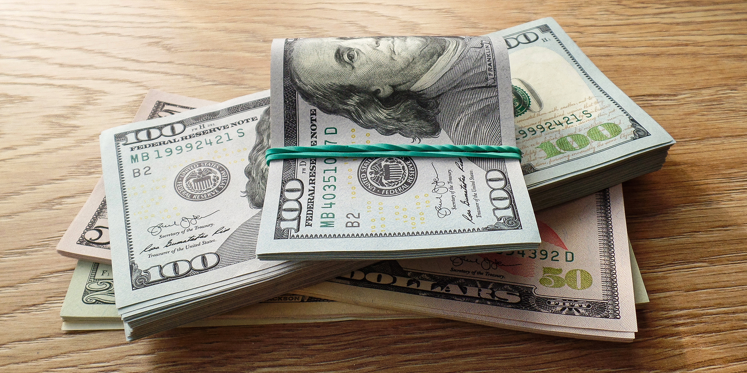 Fajos de dinero sobre una mesa | Fuente: Shutterstock