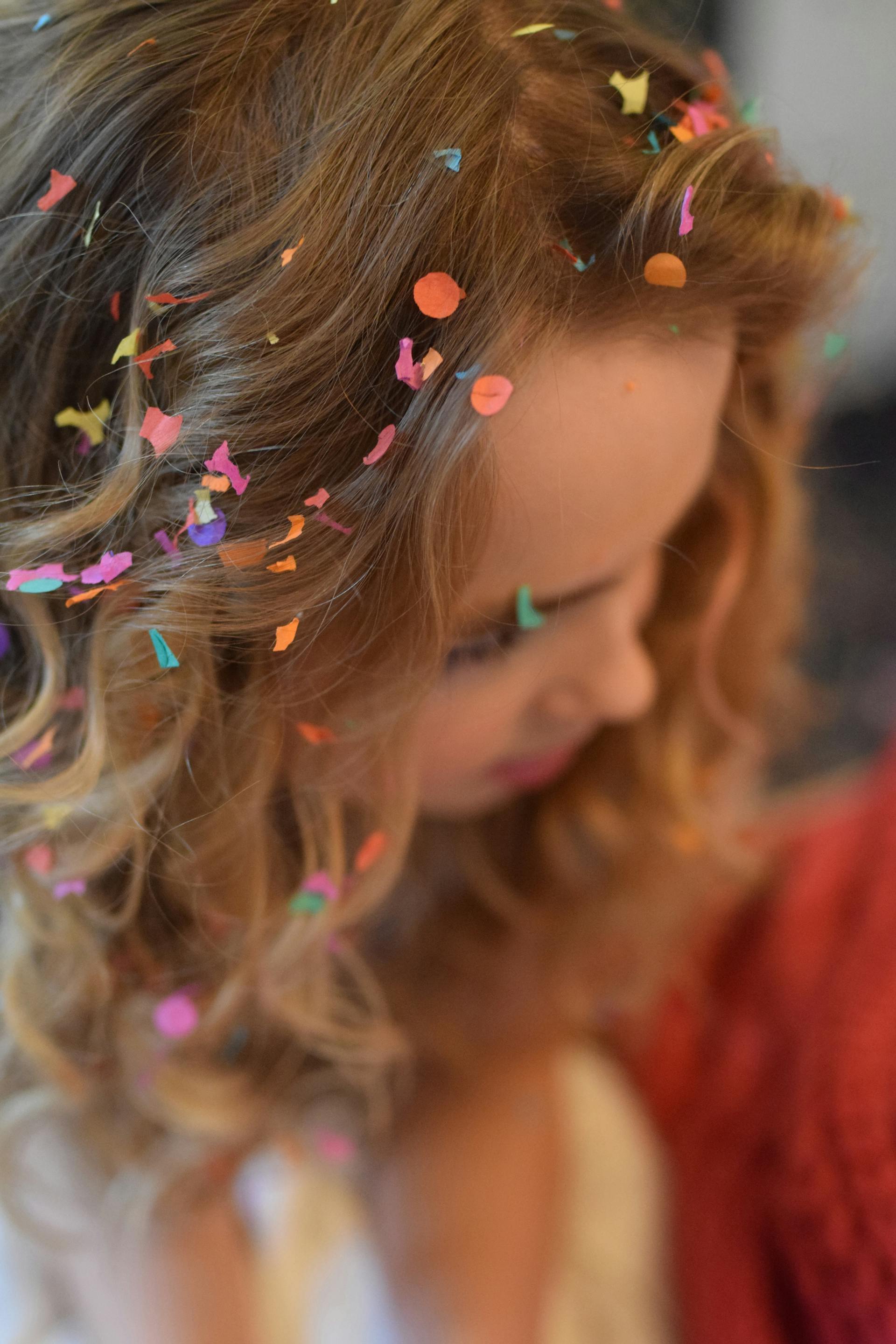 Mujer con confeti en el pelo | Fuente: Pexels