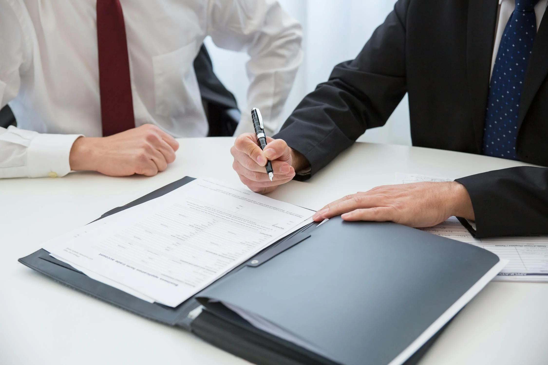 Un hombre firmando documentos | Fuente: Pexels