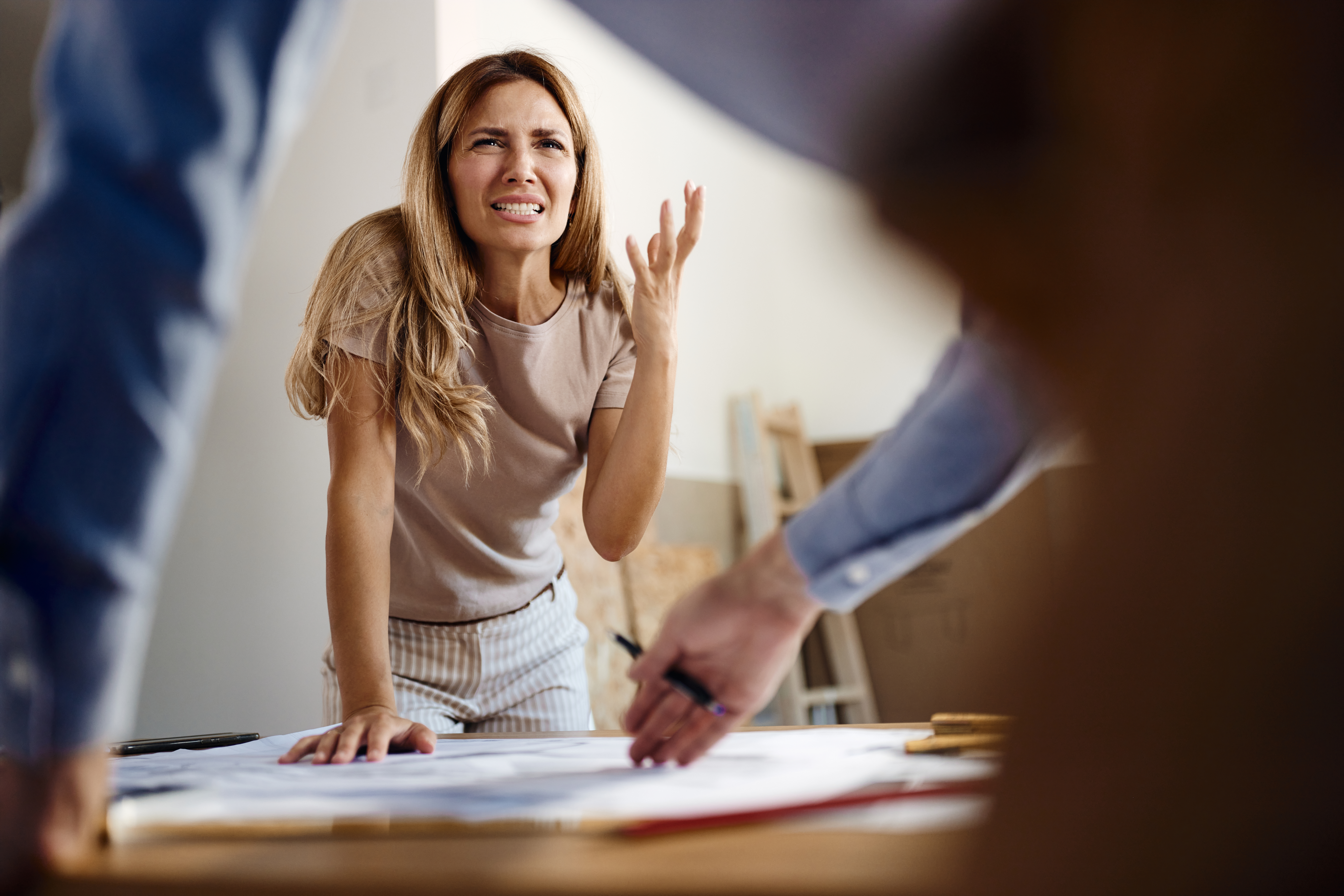 Mujer frustrada hablando con un agente inmobiliario en un apartamento | Foto: Getty Images