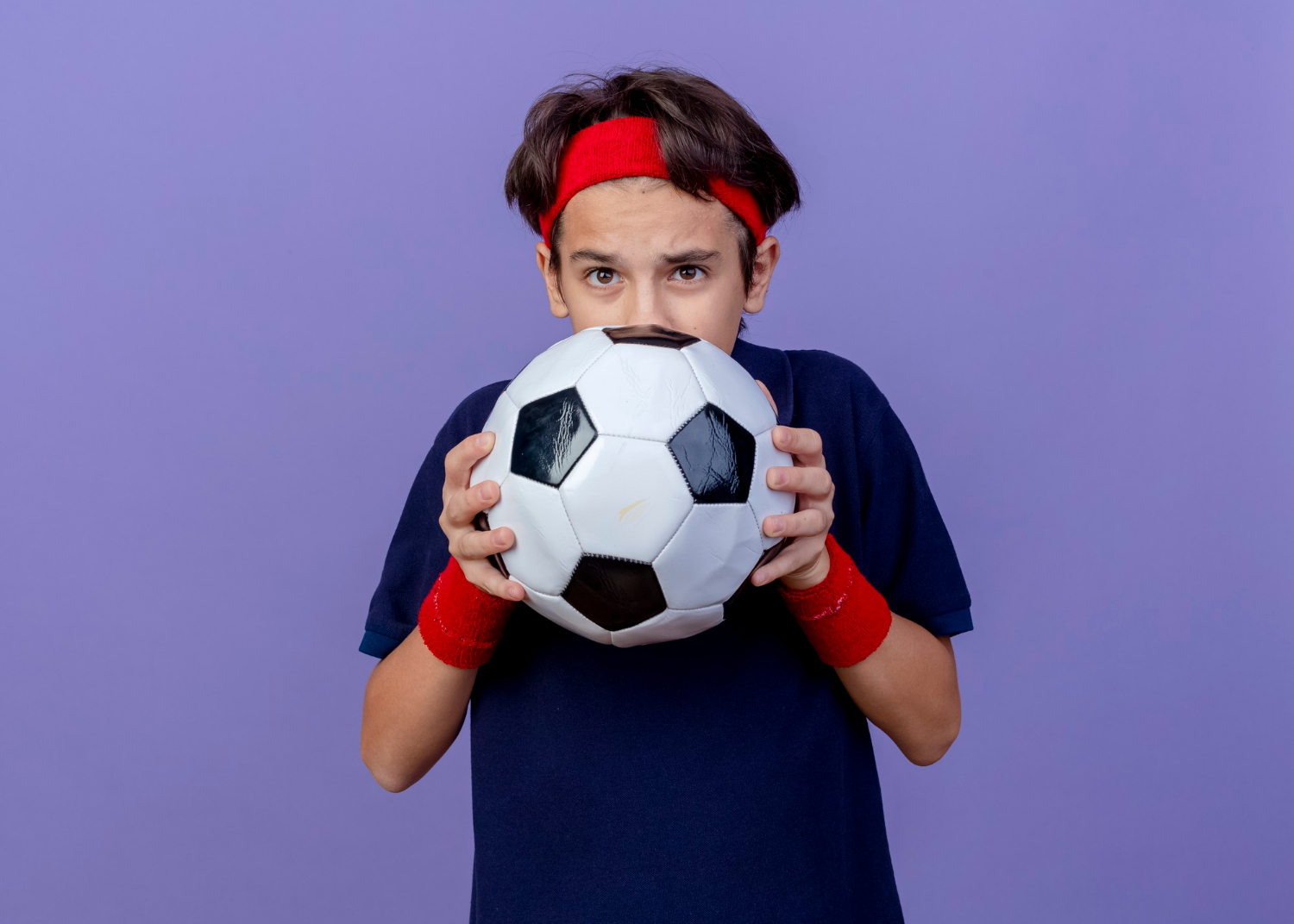 Un adolescente sujetando un balón de fútbol | Fuente: Freepik