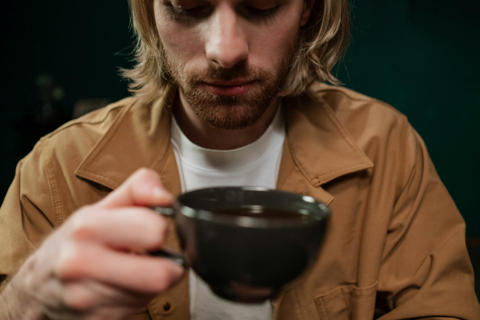 Un hombre aliviado con una taza de café en la mano | Fuente: Pexels