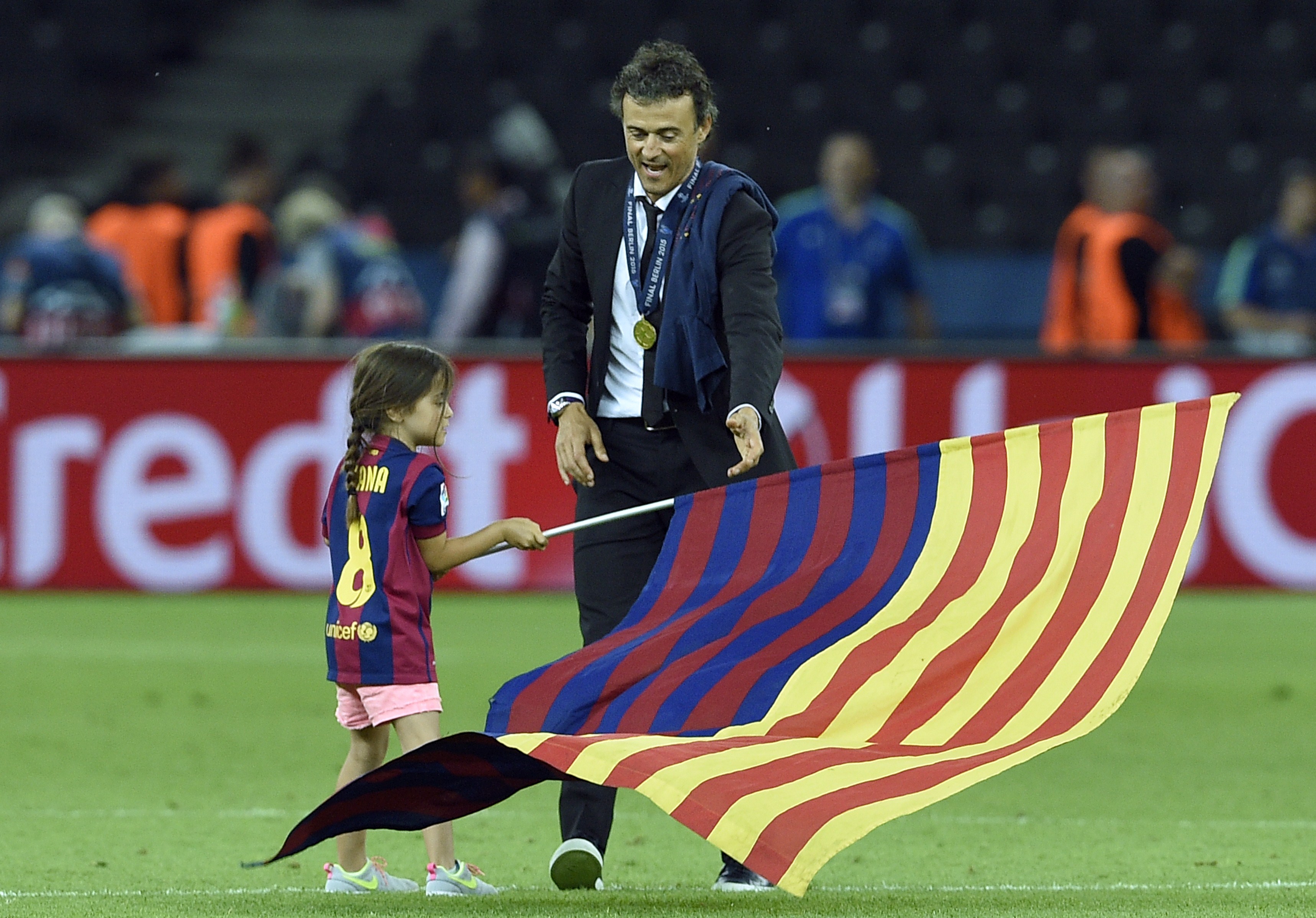 El entrenador del Barcelona, Luis Enrique, y su hija Xana ondean una bandera tras el partido de fútbol de la final de la UEFA Champions League entre la Juventus y el FC Barcelona en el Estadio Olímpico de Berlín el 6 de junio de 2015. | Fuente: Getty Images