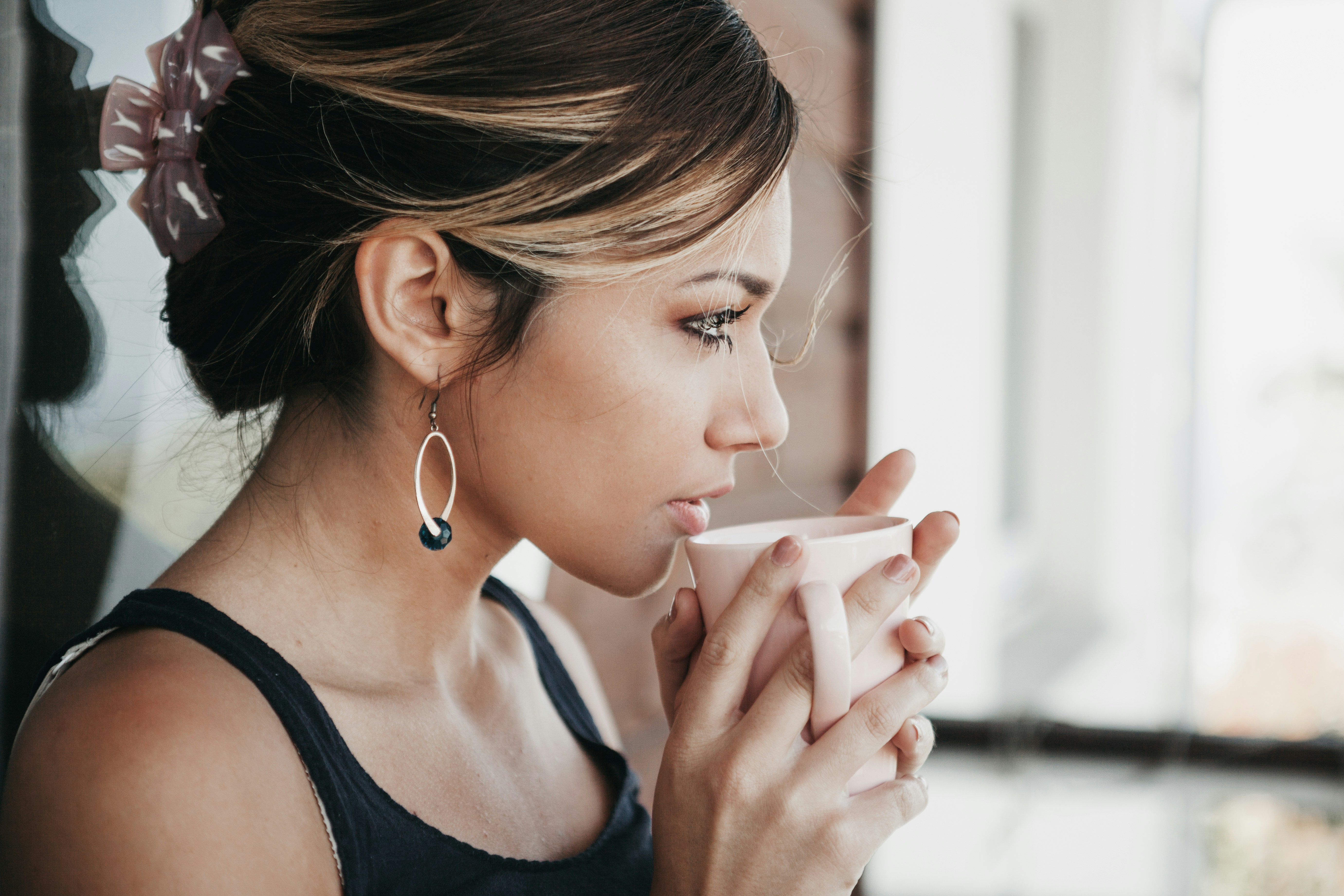 Una mujer bebiendo de una taza | Fuente: Unsplash