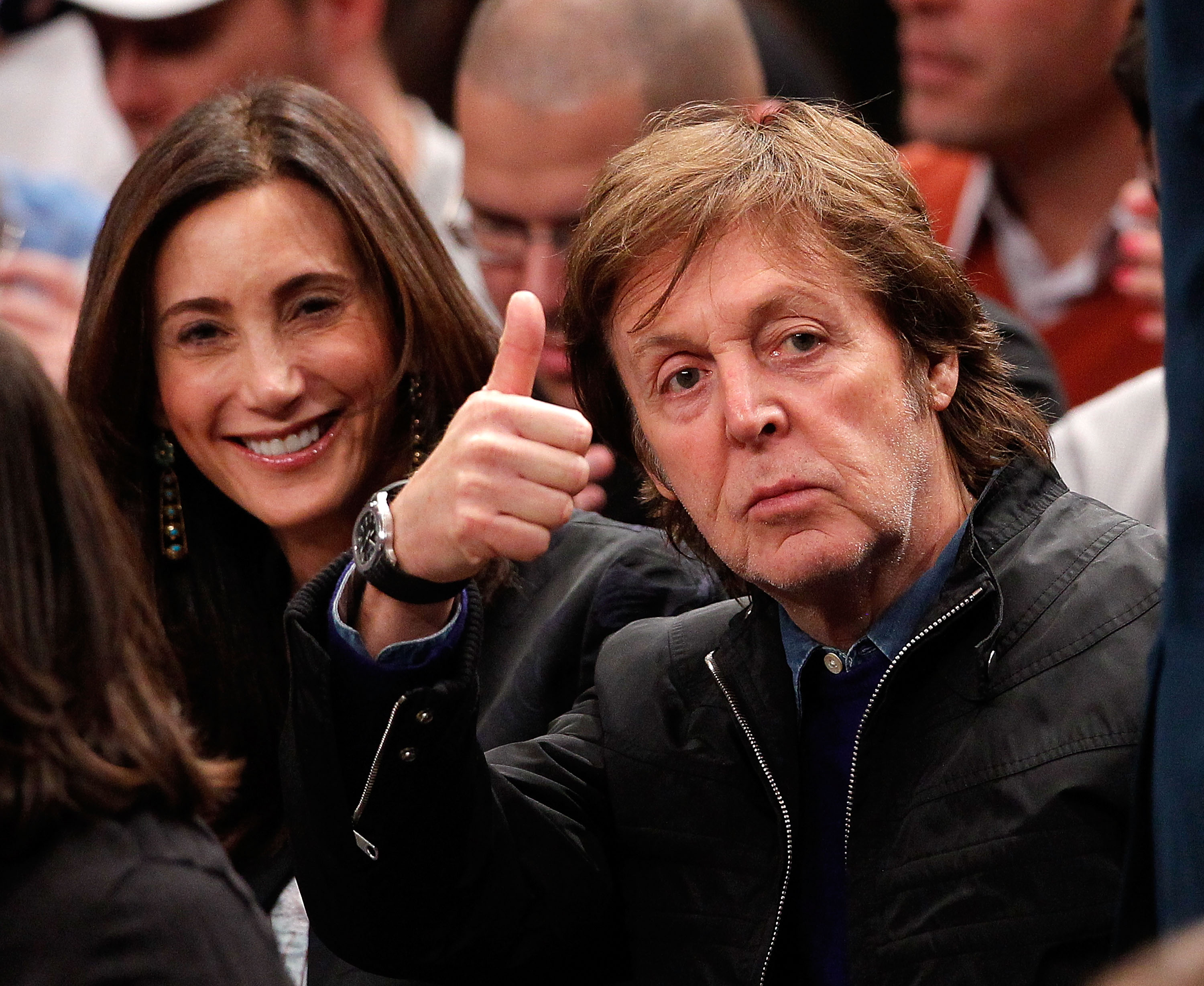 Paul McCartney saluda a los aficionados mientras su esposa Nancy Shevell sonríe durante un partido de baloncesto de la NBA en el Madison Square Garden de Nueva York, el 17 de febrero de 2012. | Fuente: Getty Images