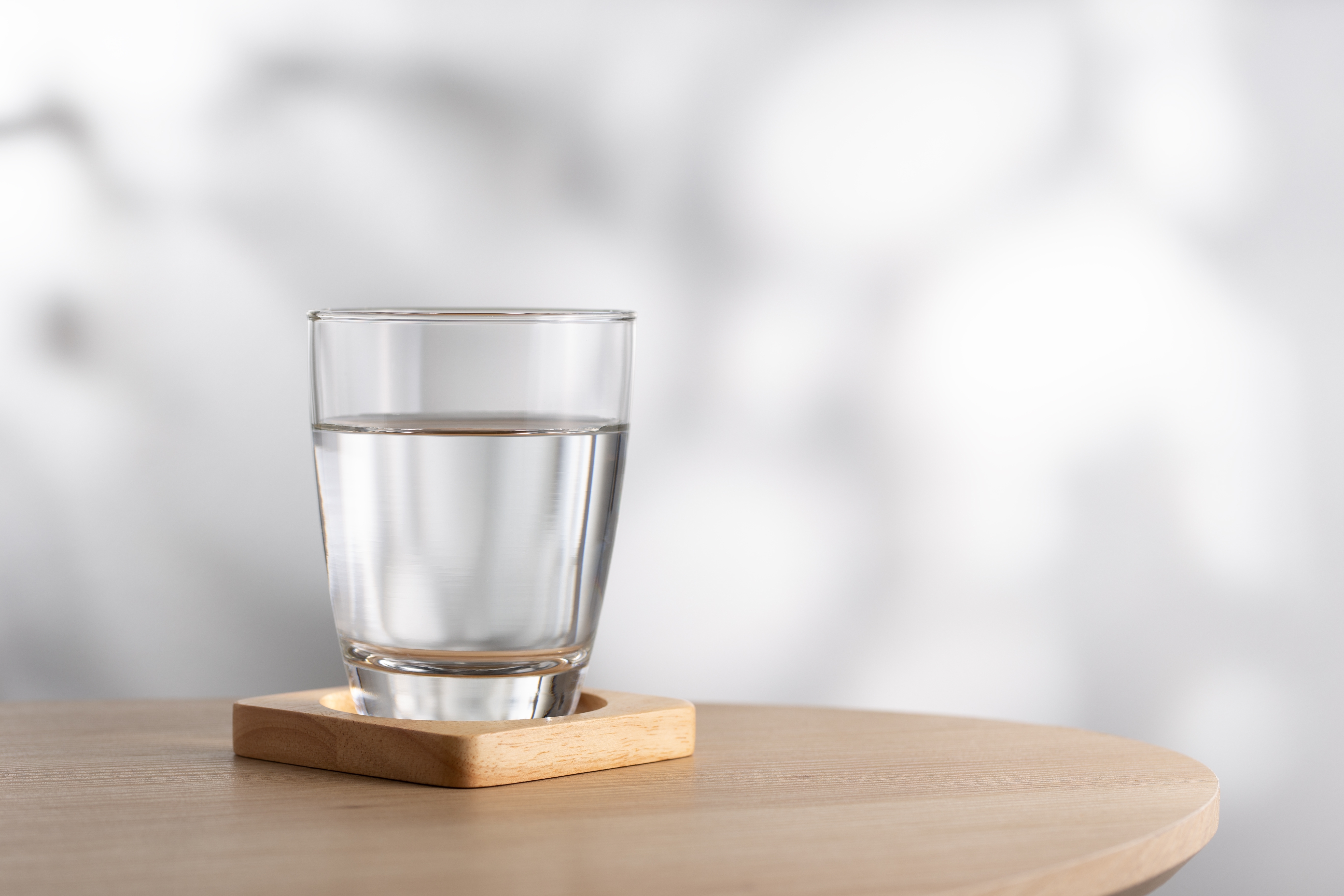 Un vaso de agua sobre una mesa de madera | Fuente: Shutterstock