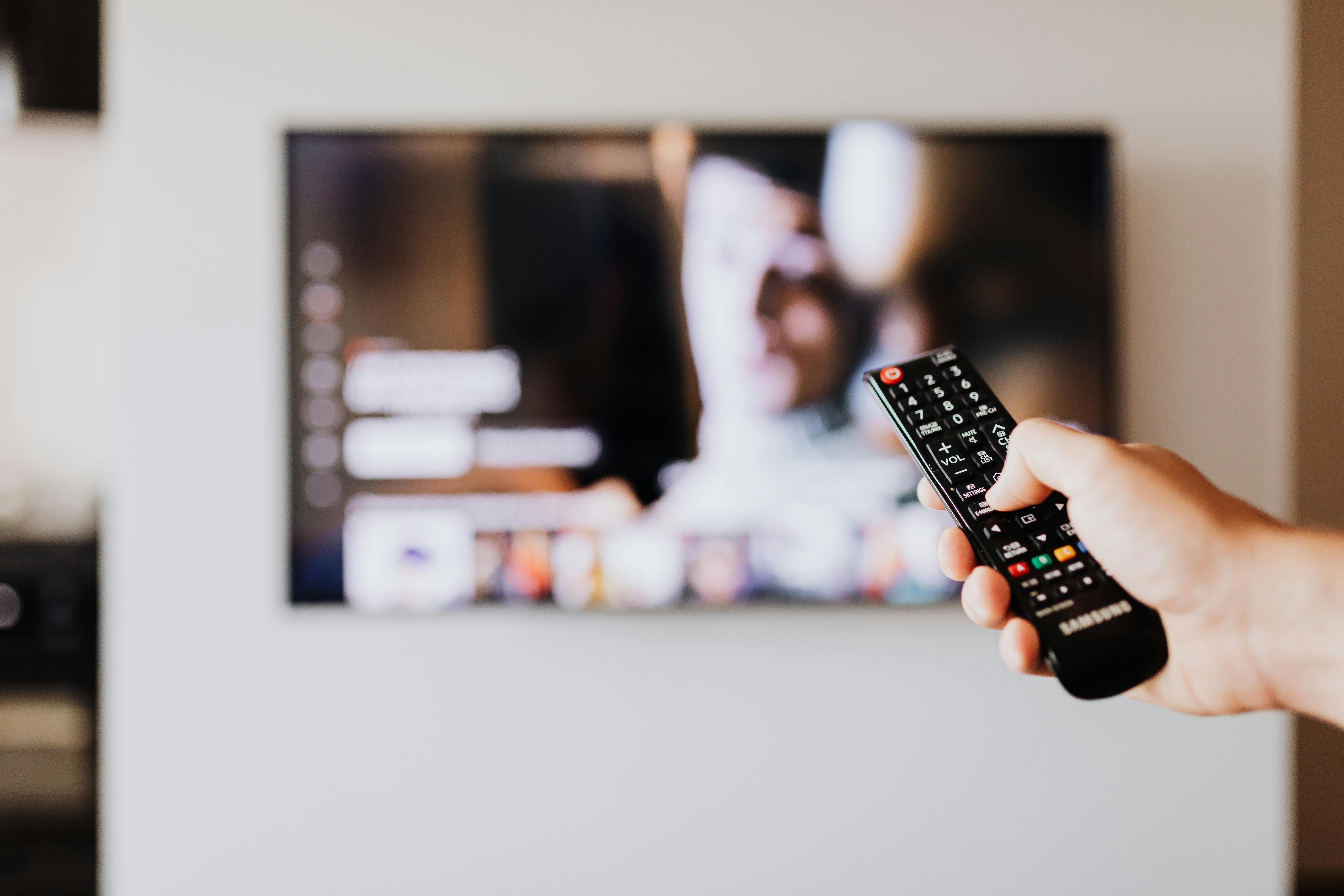 Un hombre hojeando la TV | Fuente: Pexels