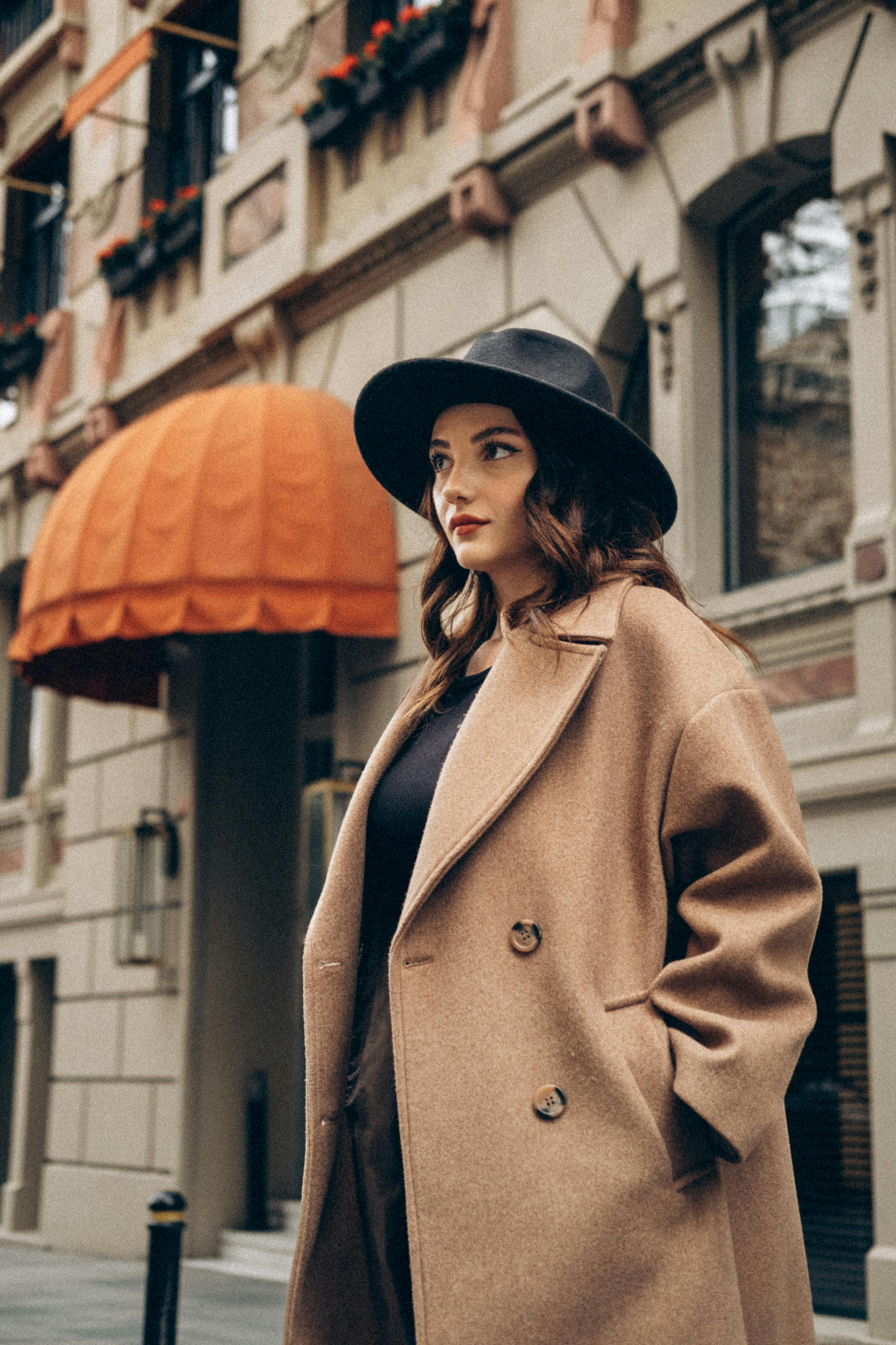 Mujer elegante con abrigo beige y sombrero | Fuente: Pexels