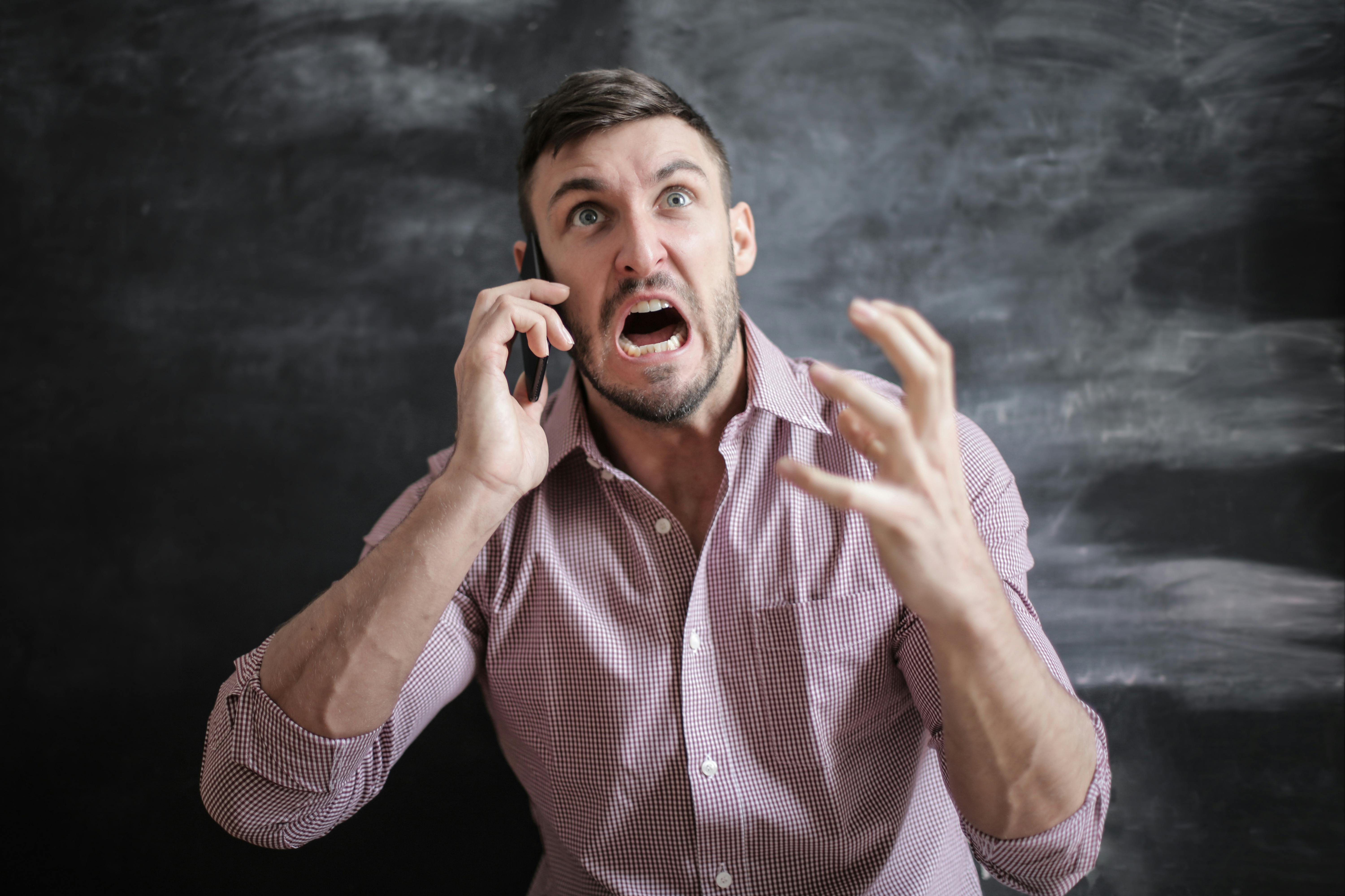 Hombre gritando al teléfono | Foto: Pexels