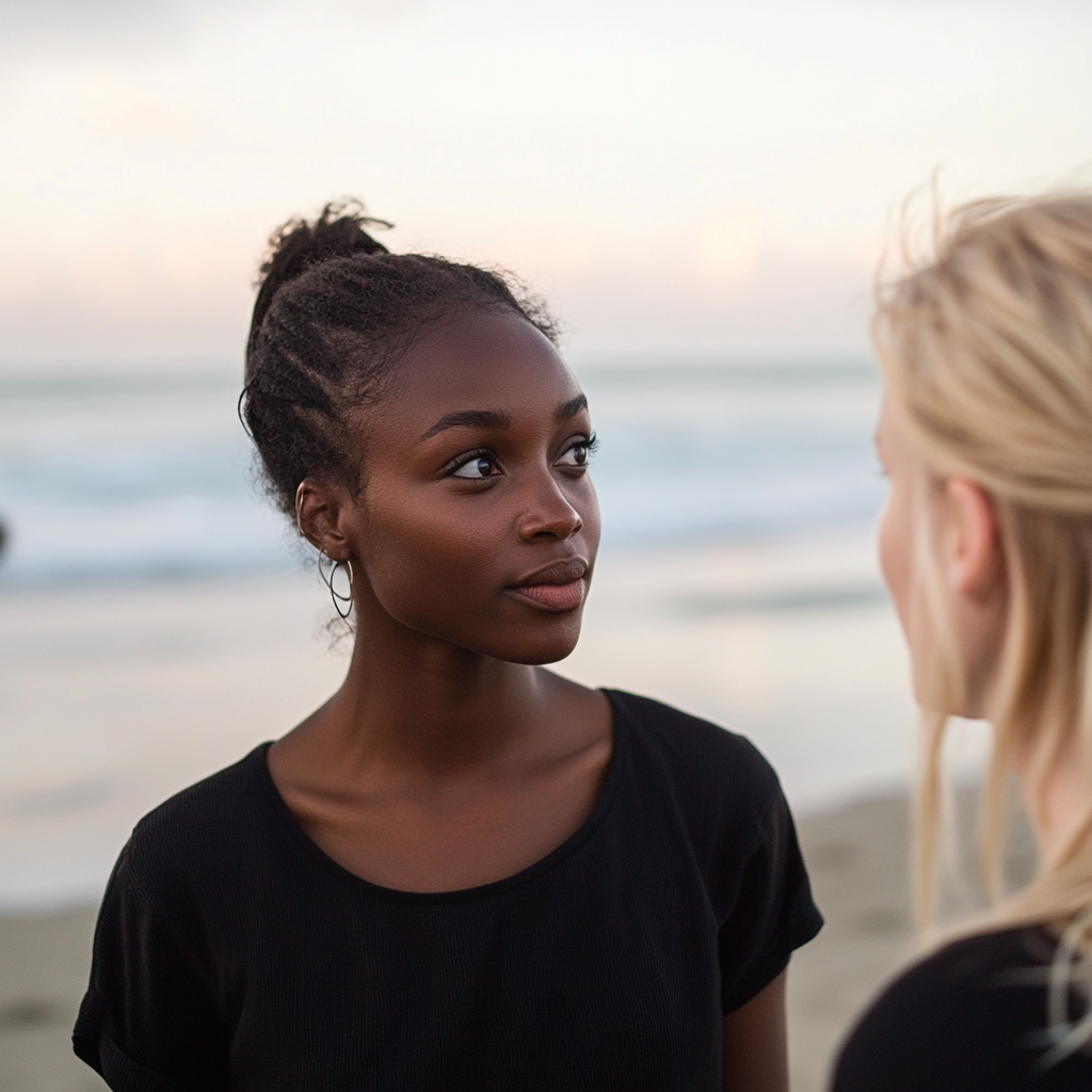 Dos mujeres hablando en la playa | Fuente: Midjourney