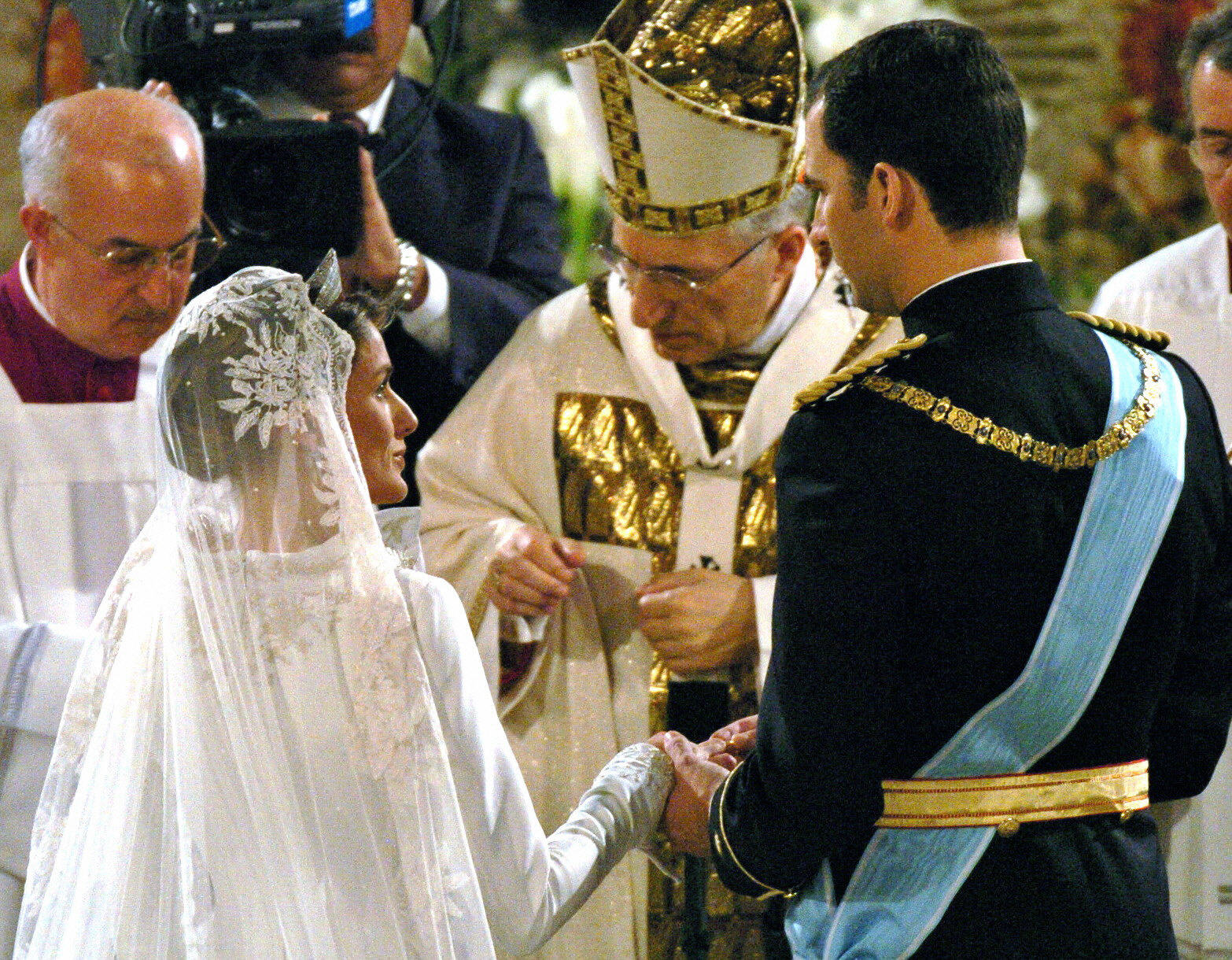 Letizia Ortiz coloca el anillo en el dedo del príncipe heredero español Felipe de Borbón durante su ceremonia de boda en la catedral de la Almudena de Madrid el 22 de mayo de 2004. | Fuente: Getty Images