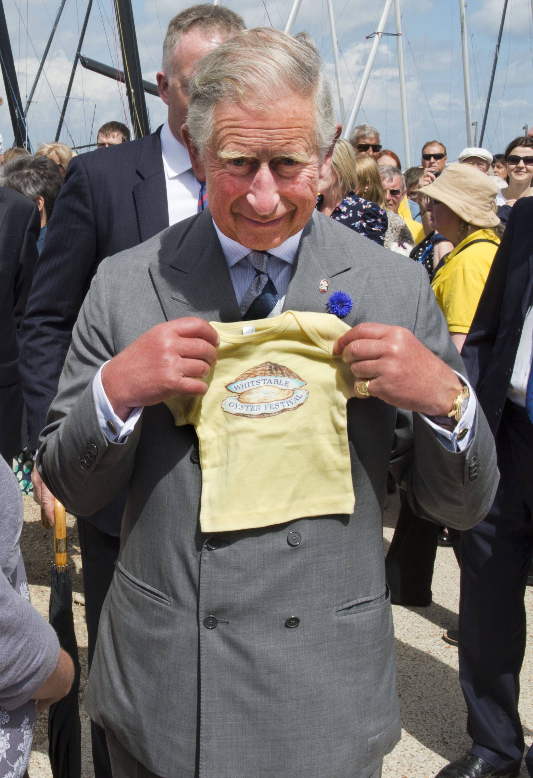 Rey Charles con un regalo para su nieto, el príncipe George de Cambridge, durante una visita al Festival de la ostra de Whitstable el 29 de julio de 2013, en el puerto de Whitstable, Whitstable, Kent | Foto: Getty Images