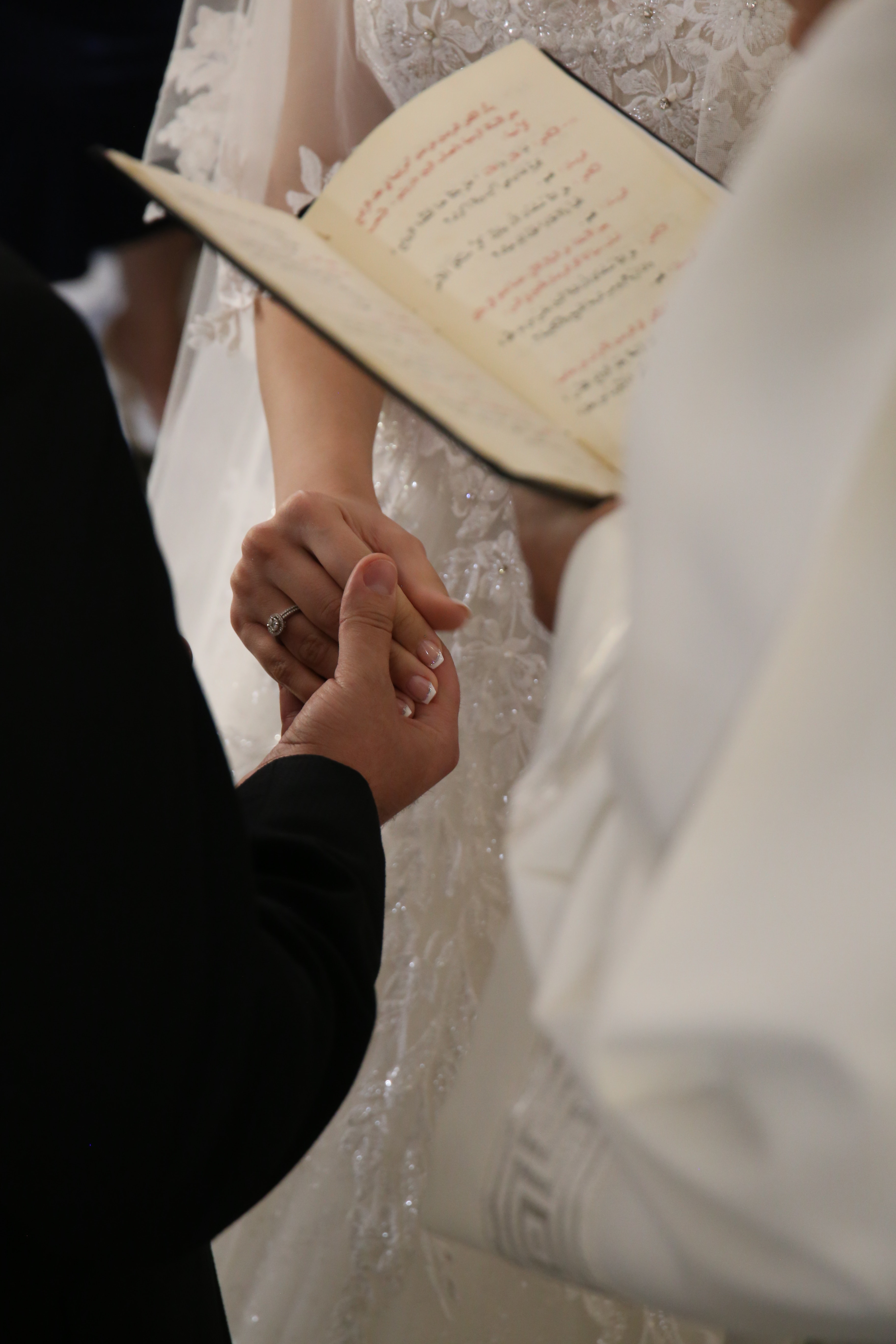 Recién casados cogidos de la mano en la ceremonia de boda | Fuente: Pexels