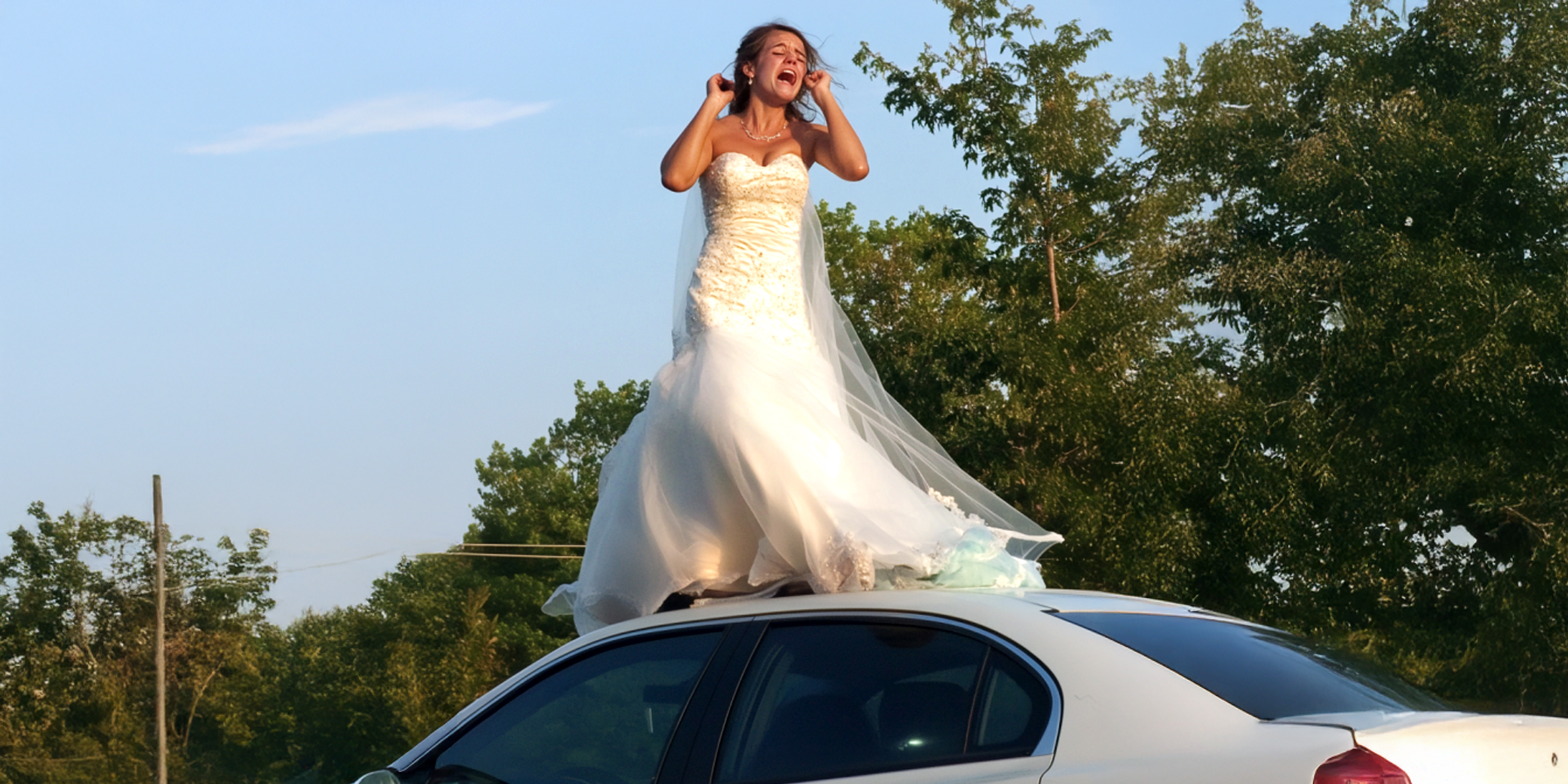 Una mujer vestida de novia de pie y llorando sobre el techo de un automóvil | Fuente: Amomama