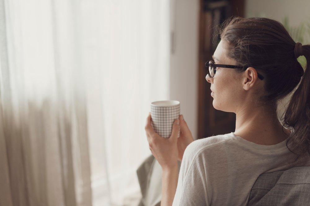 Mujer tomándose una taza de café en su casa. | Foto: Shutterstock