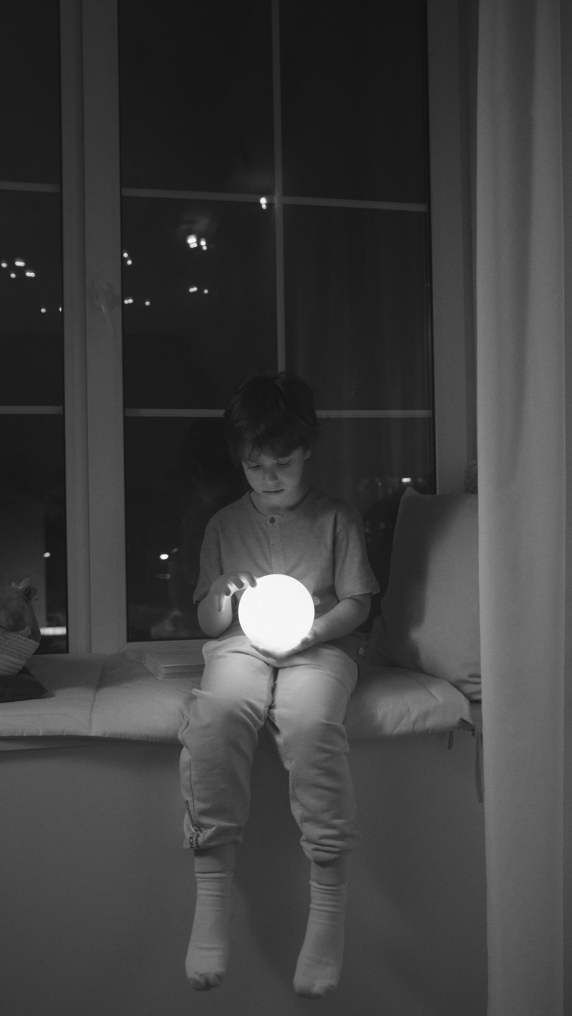 Un niño sujetando una bola de luz | Fuente: Pexels