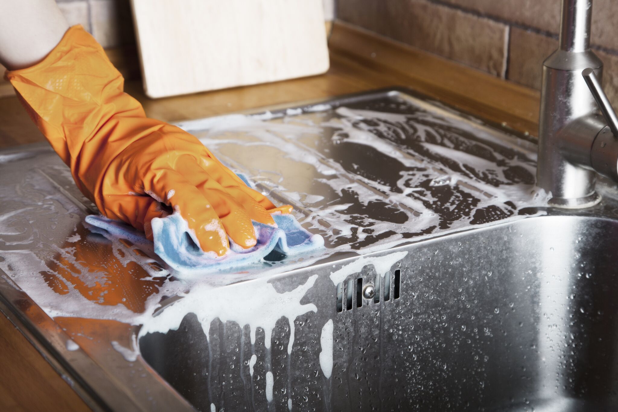 Persona limpiando tope de cocina. | Imagen: Shutterstock