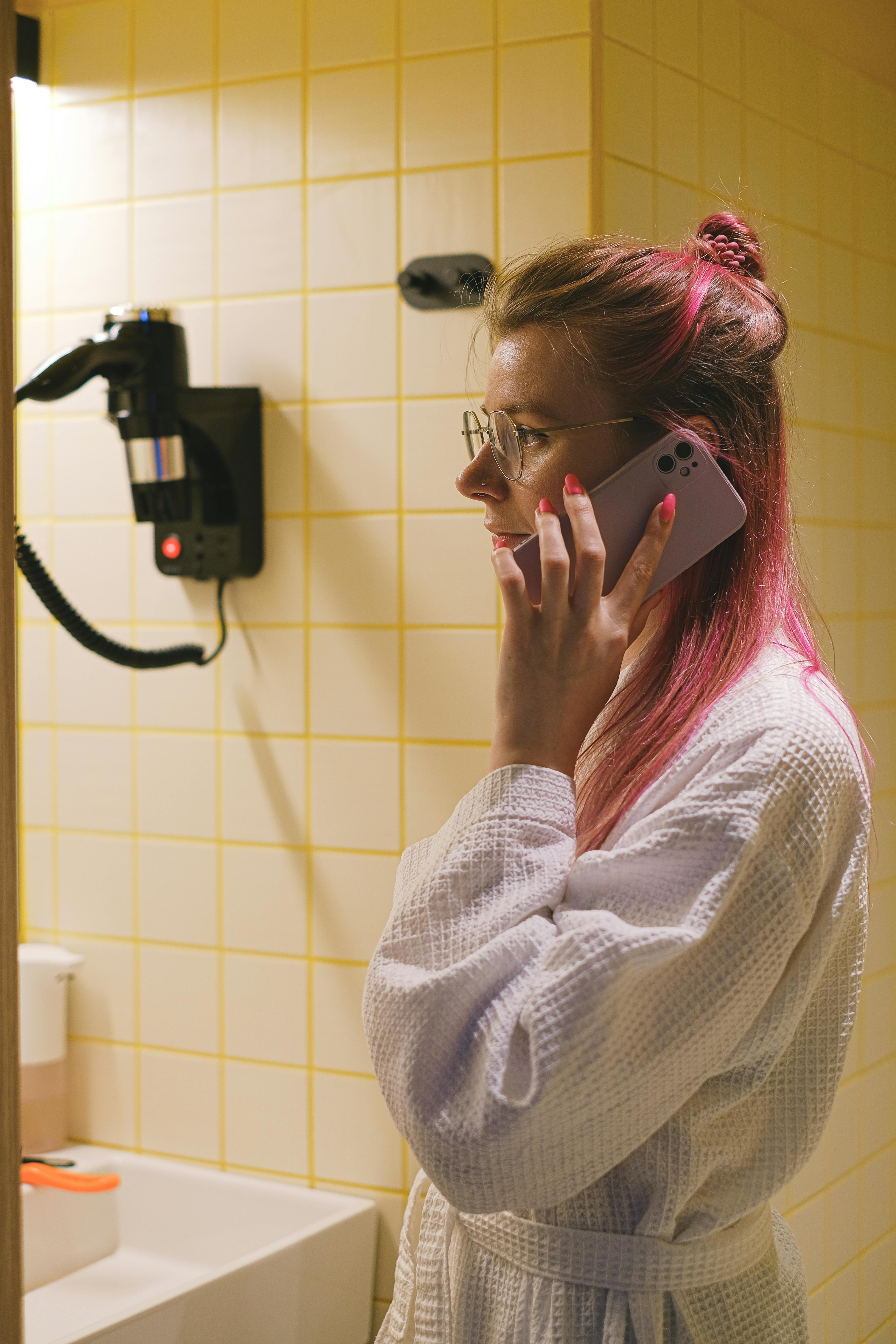 Una mujer hablando por teléfono en un baño | Fuente: Pexels