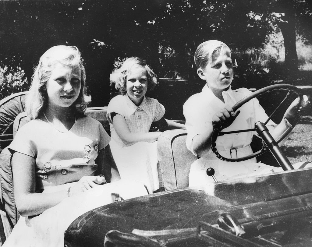 El rey Consorte Constantino de Grecia conduciendo con sus hermanas, las princesas Irene y Sofía, cuando todos eran niños, 1955. | Foto: Getty Images