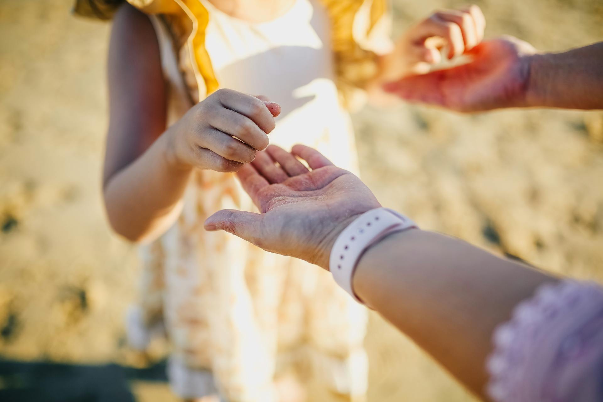 Una niña cogida de la mano de sus padres | Fuente: Pexels