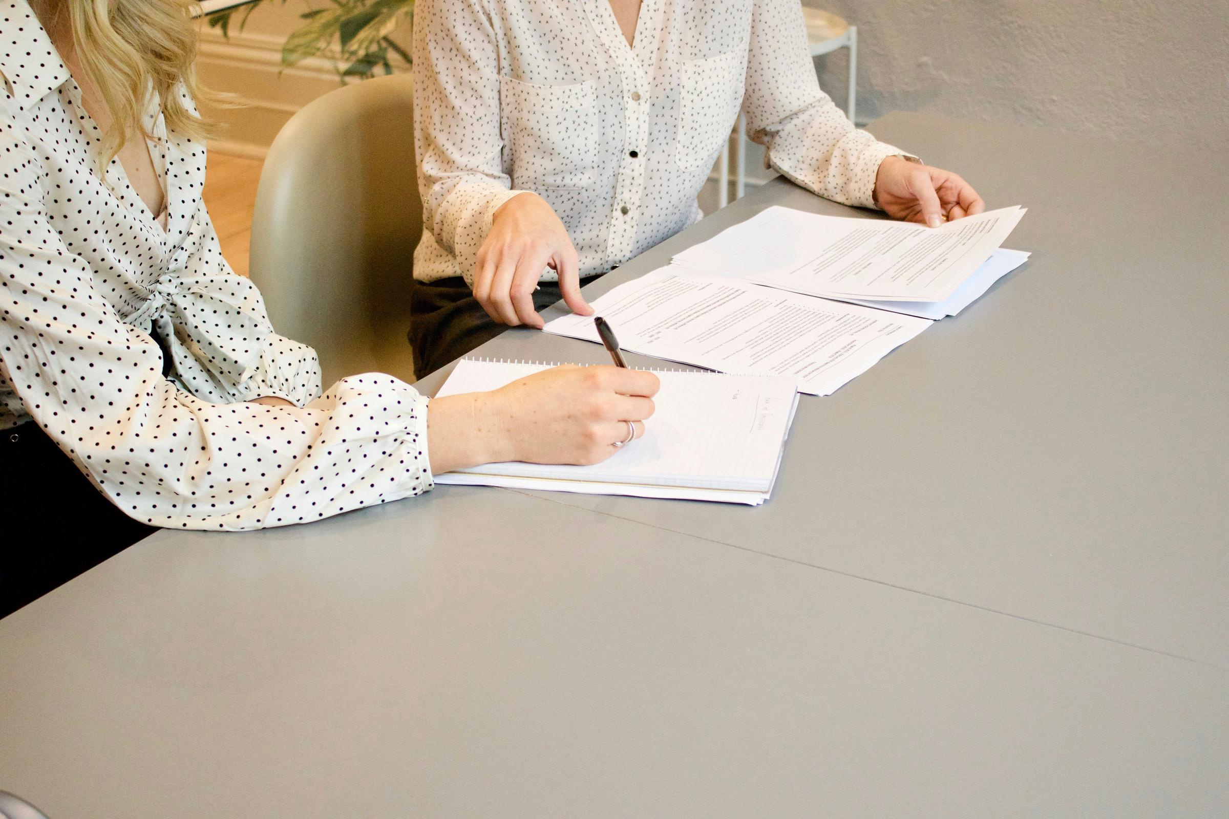 Dos mujeres sentadas en una mesa con papeles | Fuente: Unsplash