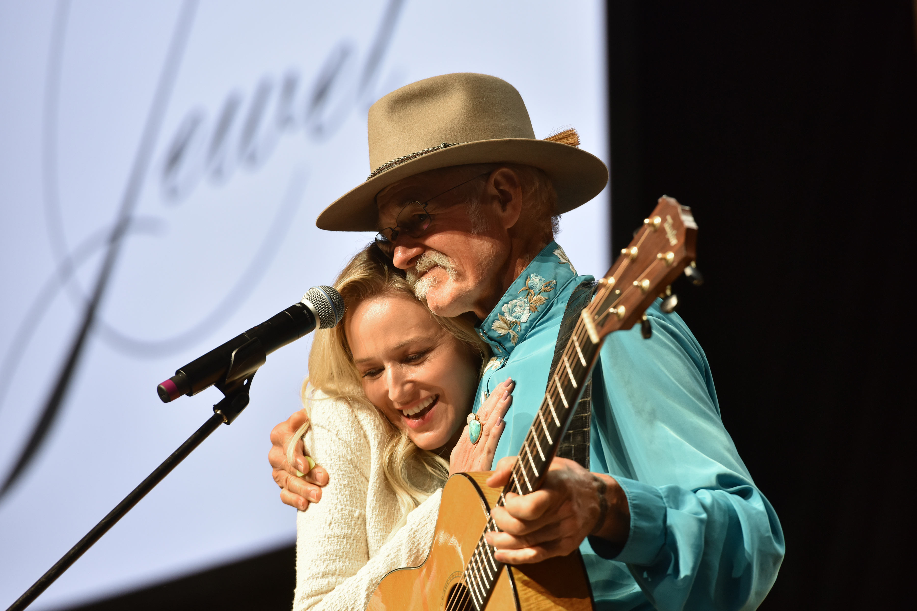 Jewel con su padre, Atz Kilcher, en el escenario durante el primer día del Festival Wellness Your Way en Denver, Colorado, el 16 de agosto de 2019. | Fuente: Getty Images