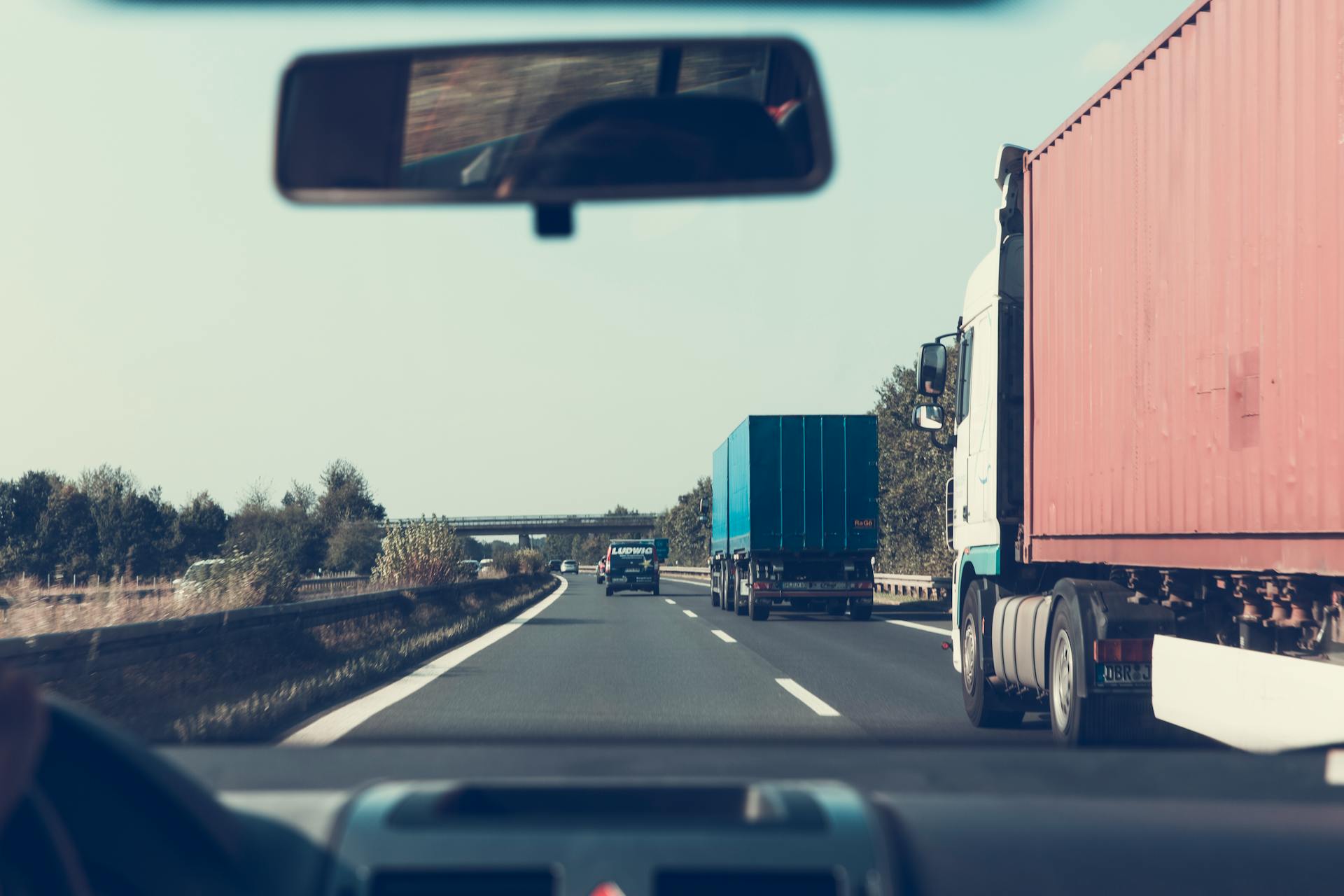 Camiones de carga azules y rojos en una autopista | Fuente: Pexels
