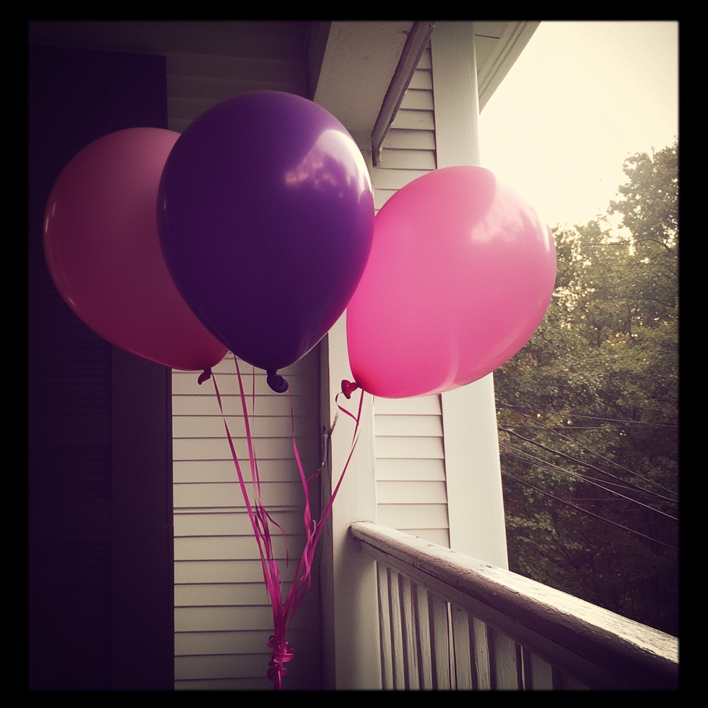 Globos rosas y morados en un porche | Fuente: Midjourney