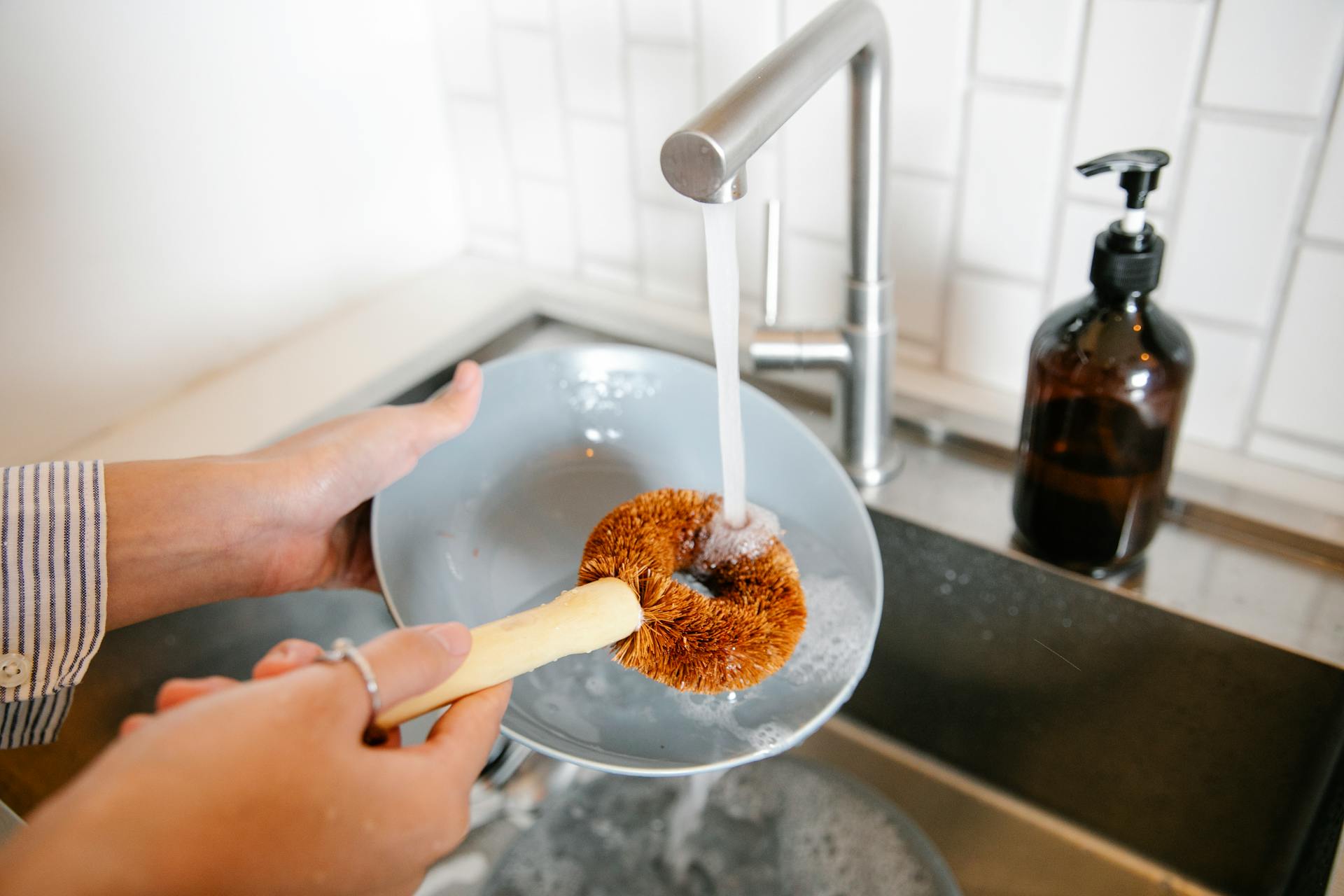 Primer plano de una mujer lavando los platos en la cocina | Fuente: Pexels