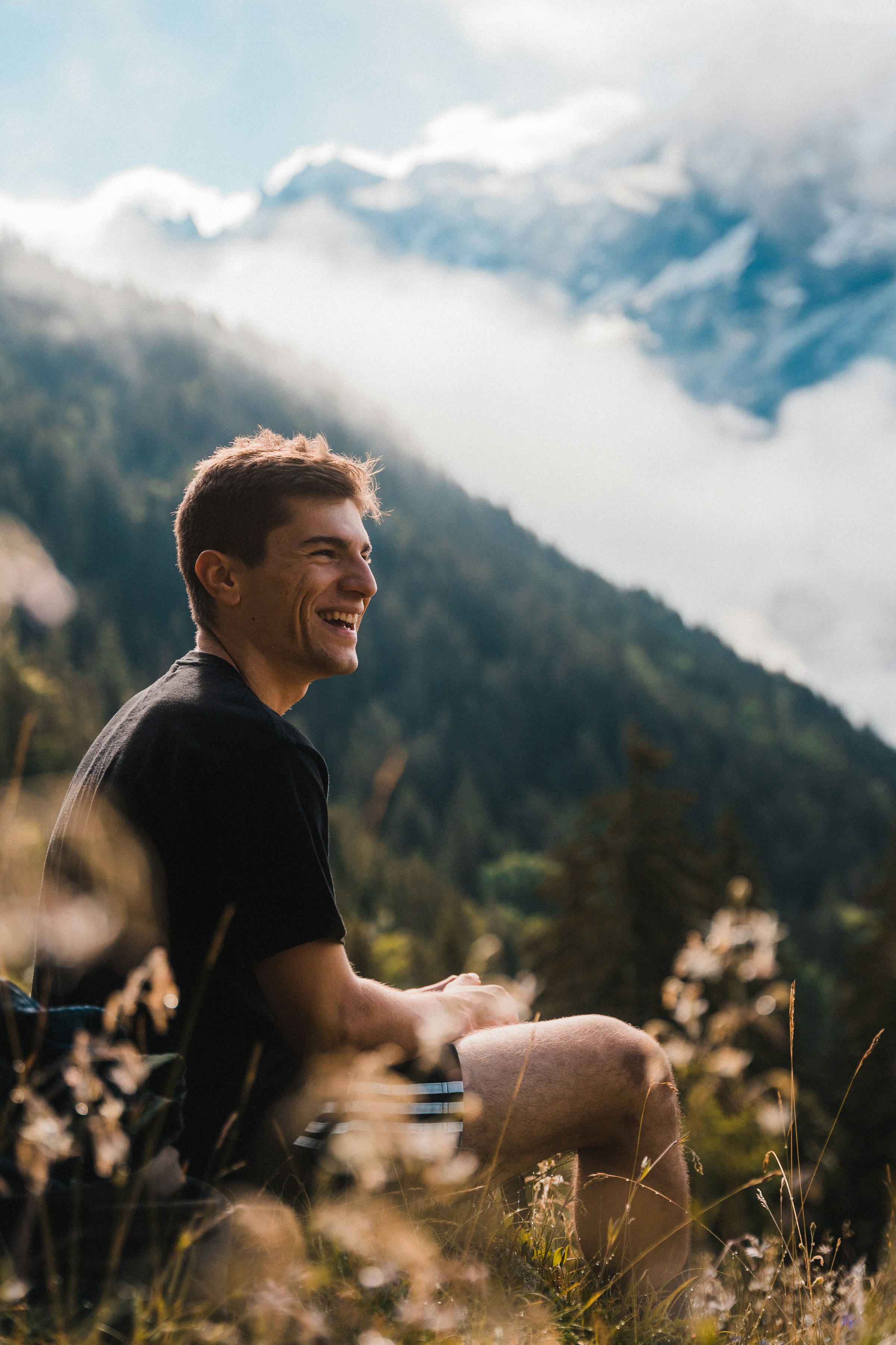 Un hombre sonriente sentado al aire libre | Fuente: Unsplash