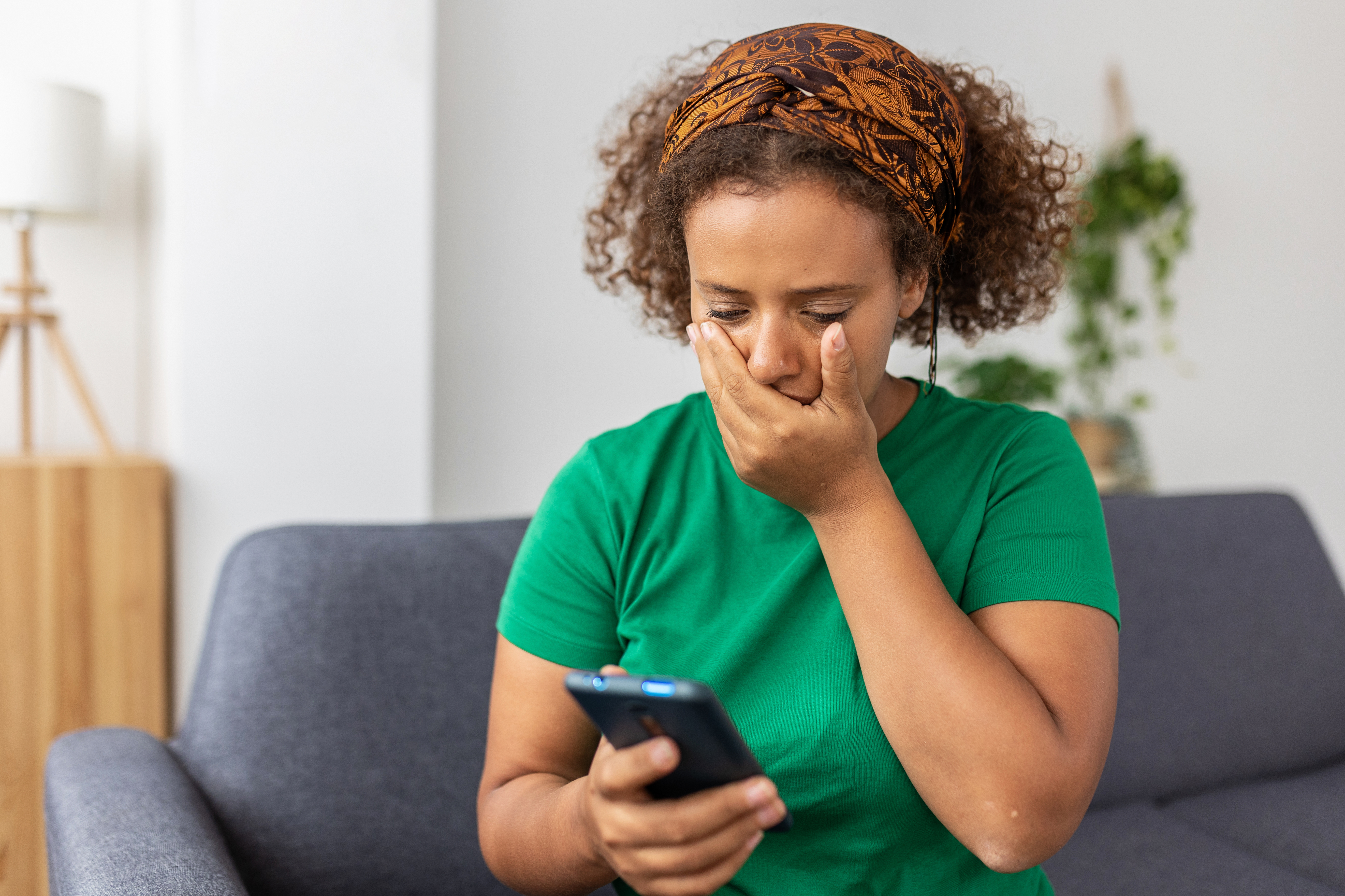 Mujer angustiada mirando su teléfono con incredulidad | Foto: Getty Images