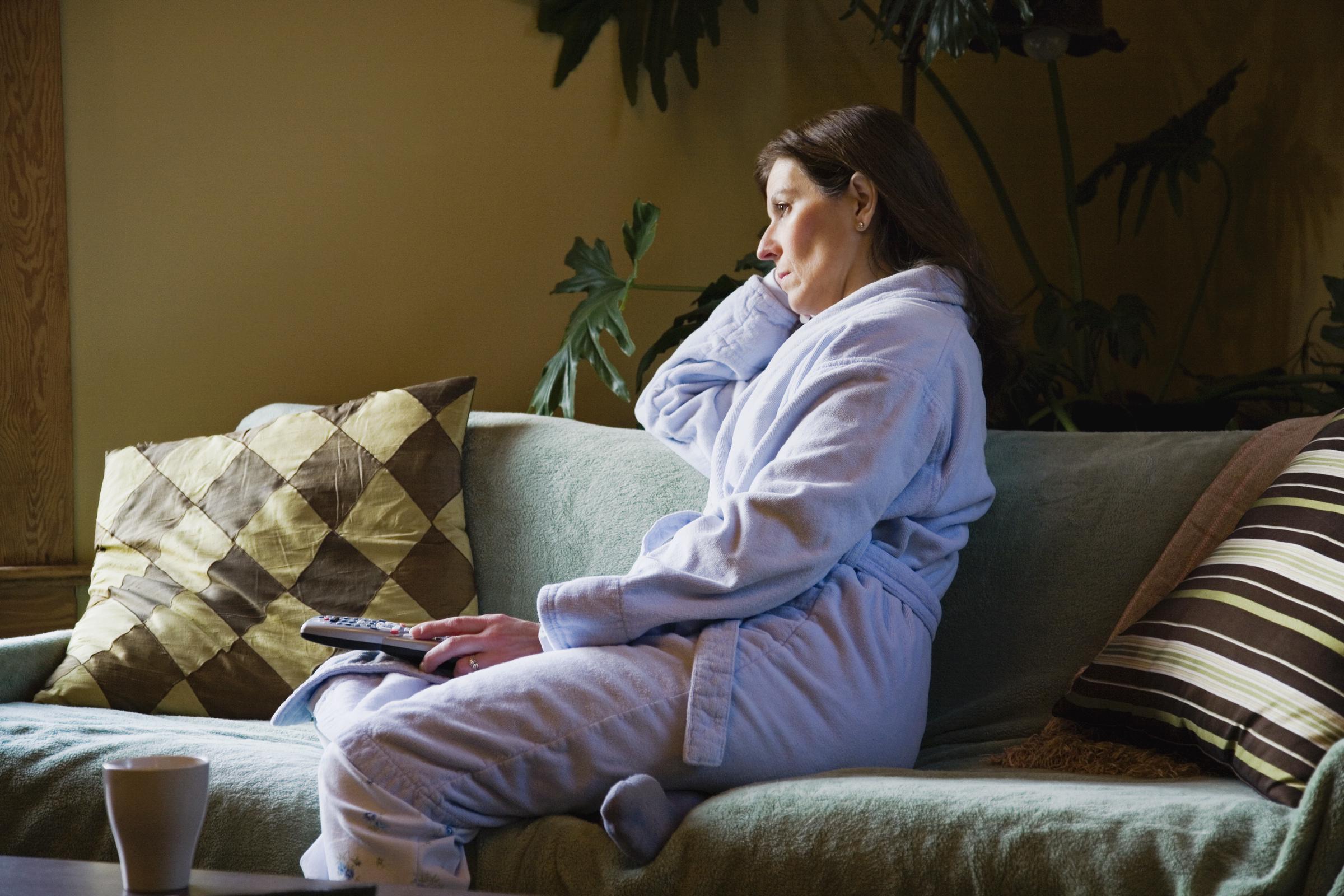 Una mujer viendo la tele sola en pijama | Fuente: Getty Images