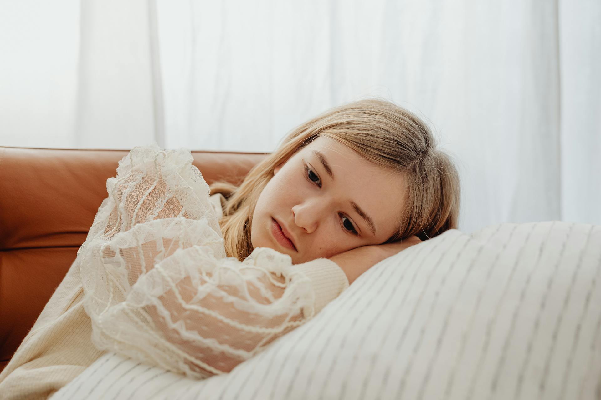 Una adolescente triste tumbada sobre una almohada | Fuente: Pexels