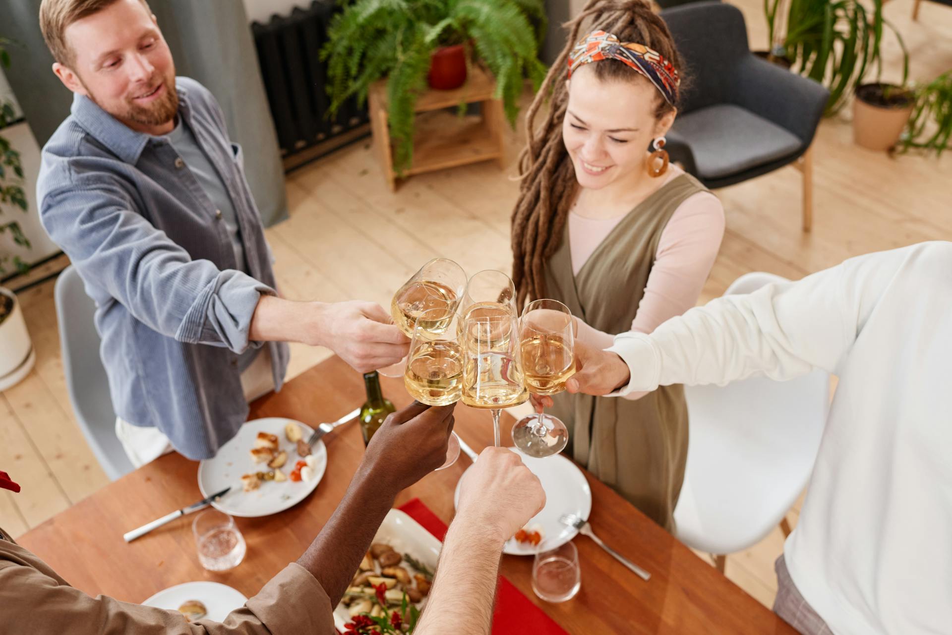 Gente chocando copas en una cena | Fuente: Pexels