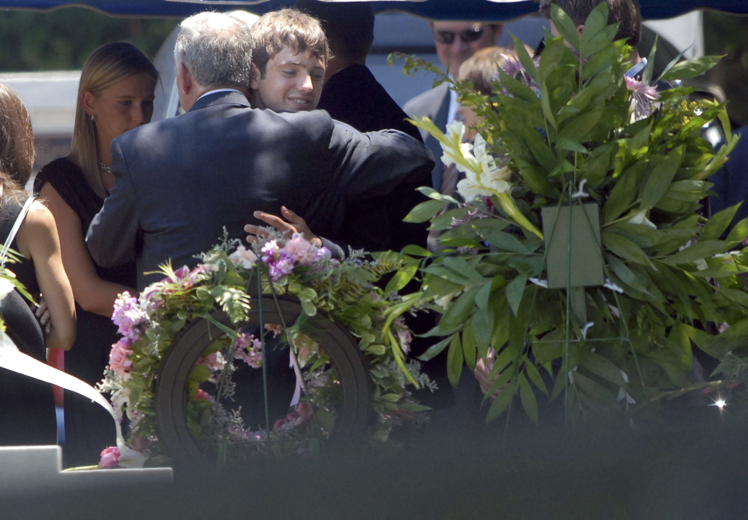 John Ramsey abraza a Burke Ramsey en la tumba de JonBenet Ramsey el 29 de junio de 2006, en Marietta, Georgia | Fuente: Getty Images